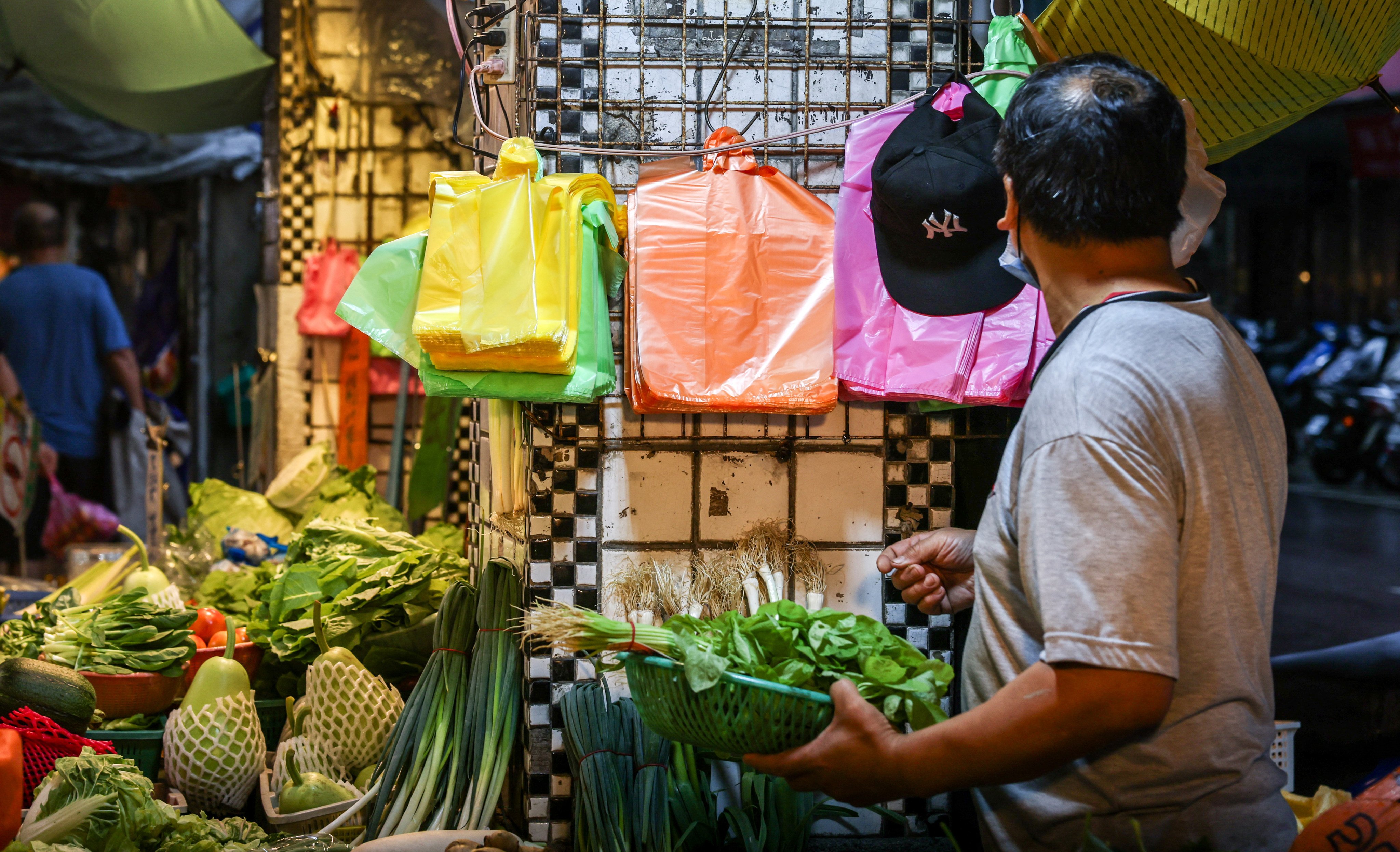 Plastic bags hang at a vegetable stall in a traditional market in Keelung on June 9, 2026. Vendors in Asia who use plastics for everything from bags to cups to containers are grappling with rising costs from the energy crisis sparked by the Middle East war. (Photo by I-Hwa Cheng / AFP) / To go with ‘War-Iran-Us-Israel-Asia-War-Energy-Plastics’ Focus by Joy Chiang with AFP bureaus in Asia