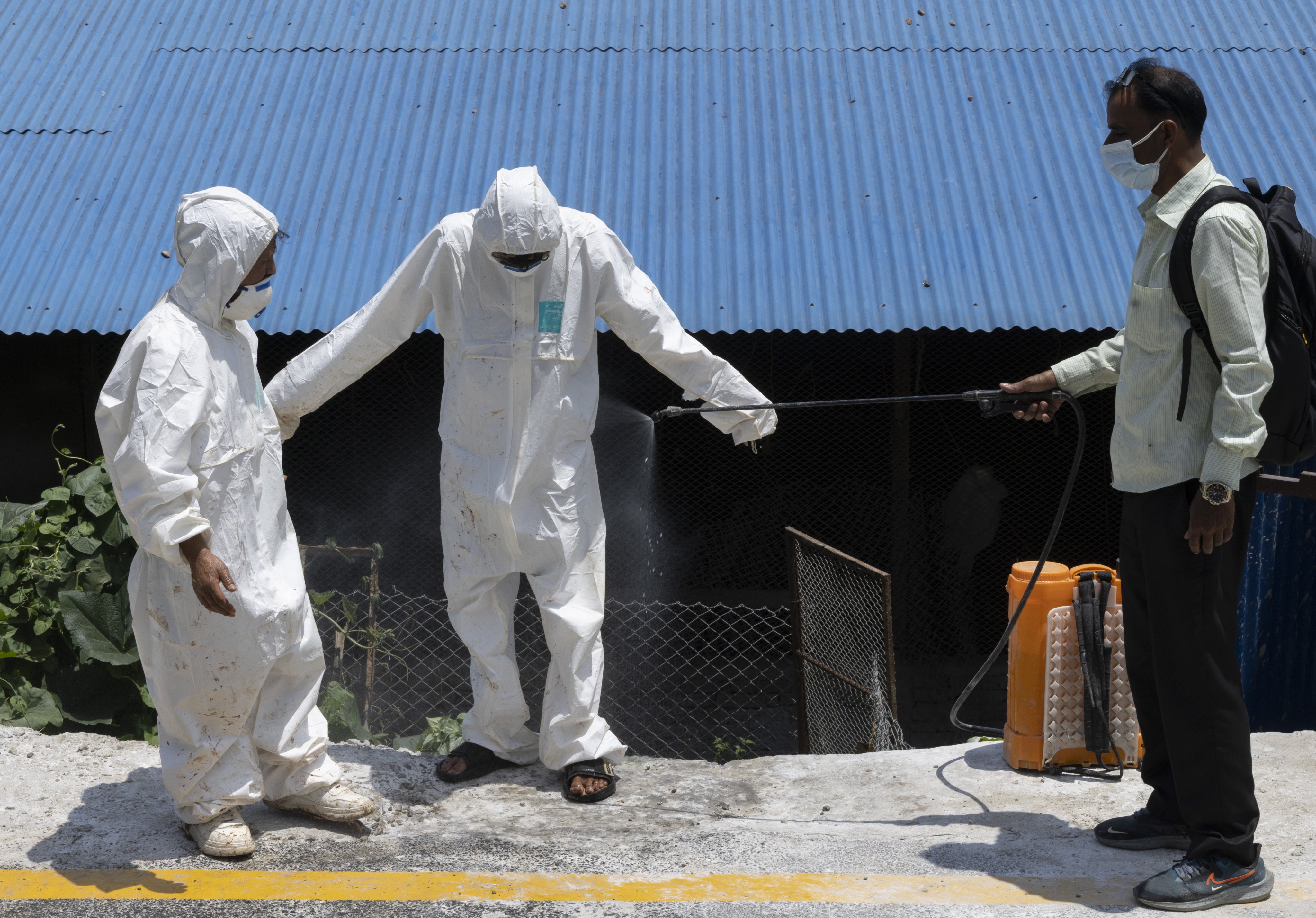 Members of a rapid response team from Nepal’s Department of Livestock Services are disinfected after culling chickens at a poultry farm in Bhaktapur last week. Photo: EPA