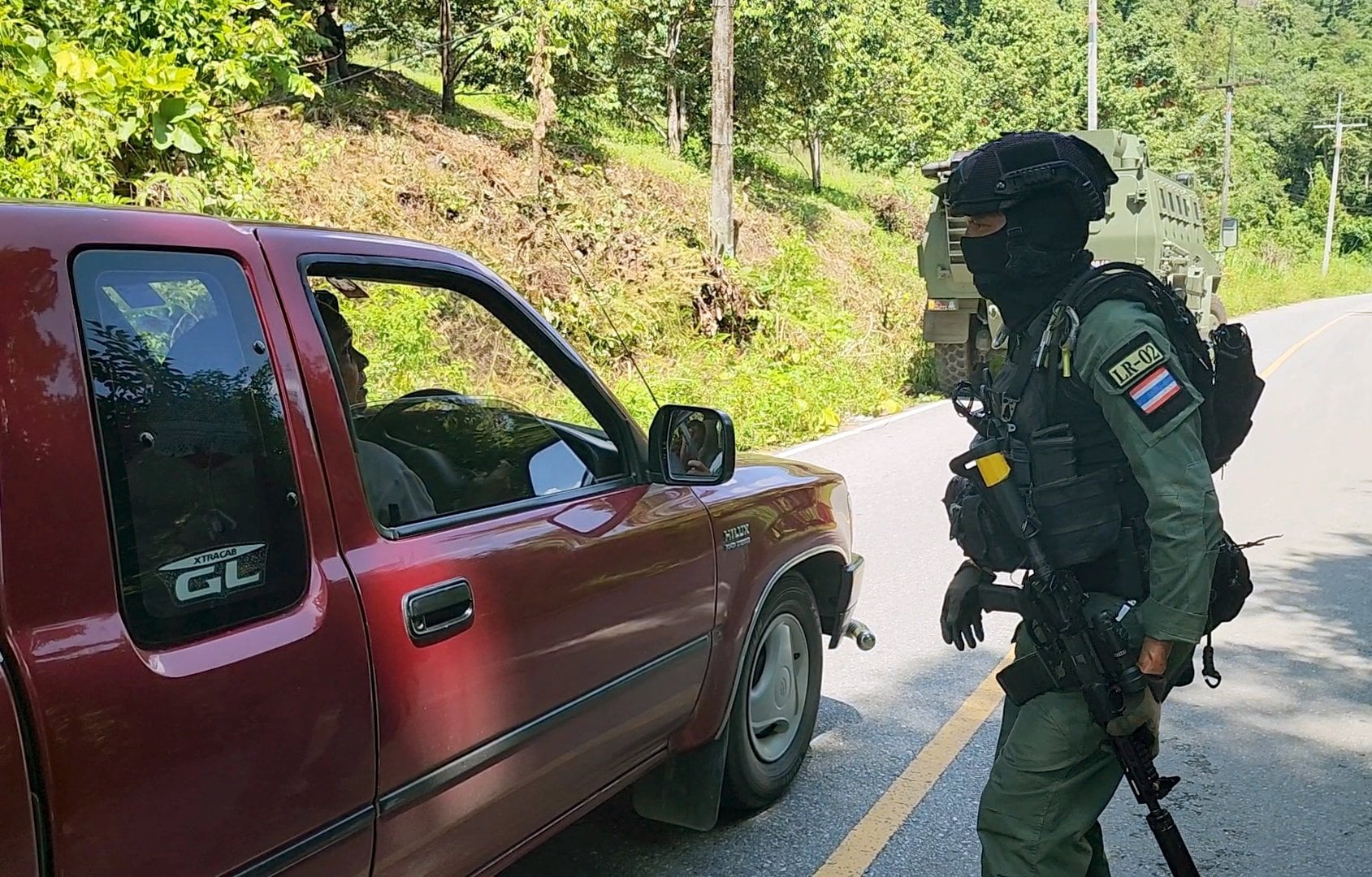 A Thai border patrol policeman inspects a villager’s vehicle on June 19. Photo: EPA