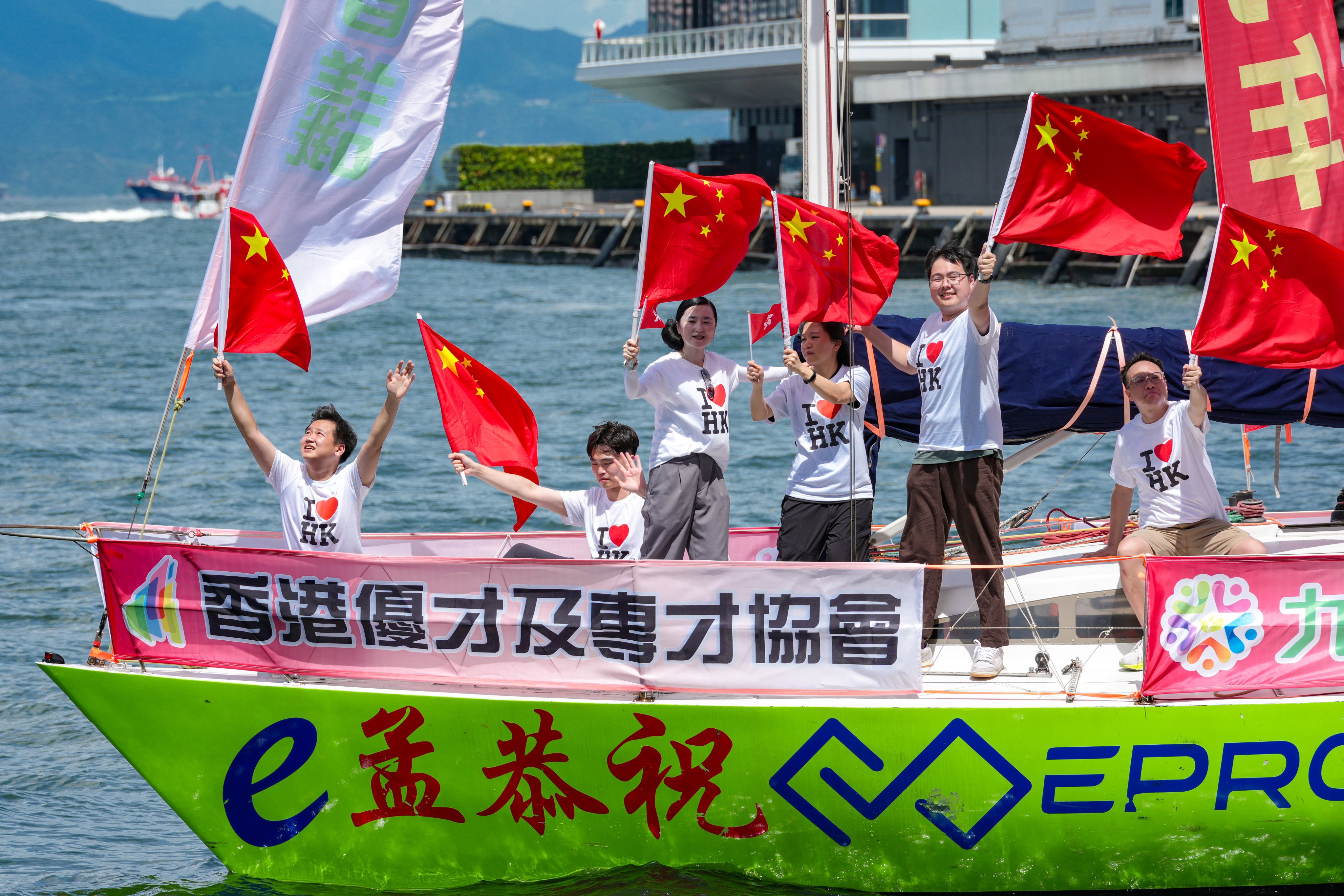 People on a boat wave national flags at the Tsim Sha Tsui waterfront. Photo: Jelly Tse