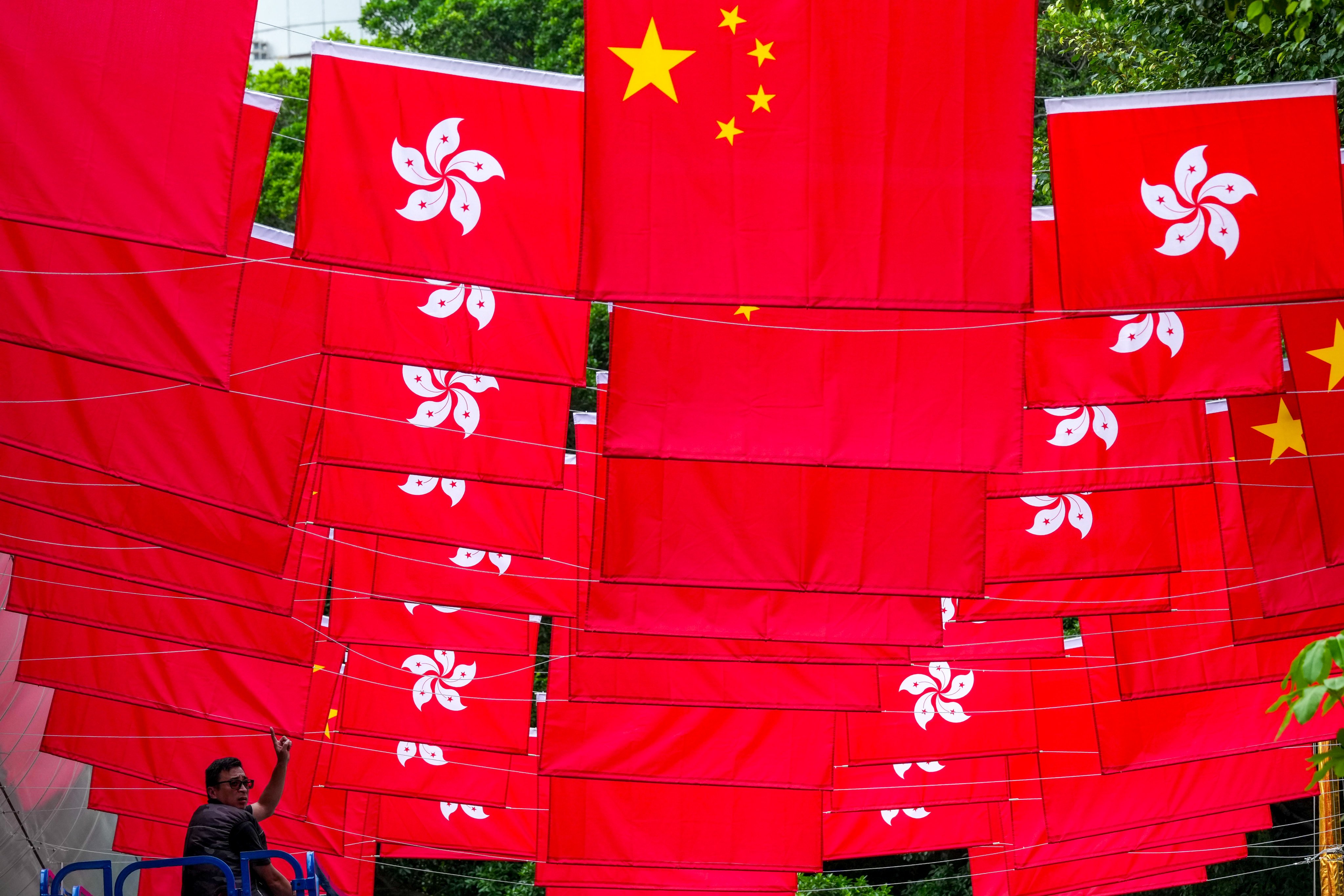 A worker installs Chinese national and Hong Kong special administrative region flags in Tsim Sha Tsui, ahead of the 29th anniversary of Hong Kong’s return to the motherland on June 25. Photo: Jelly Tse