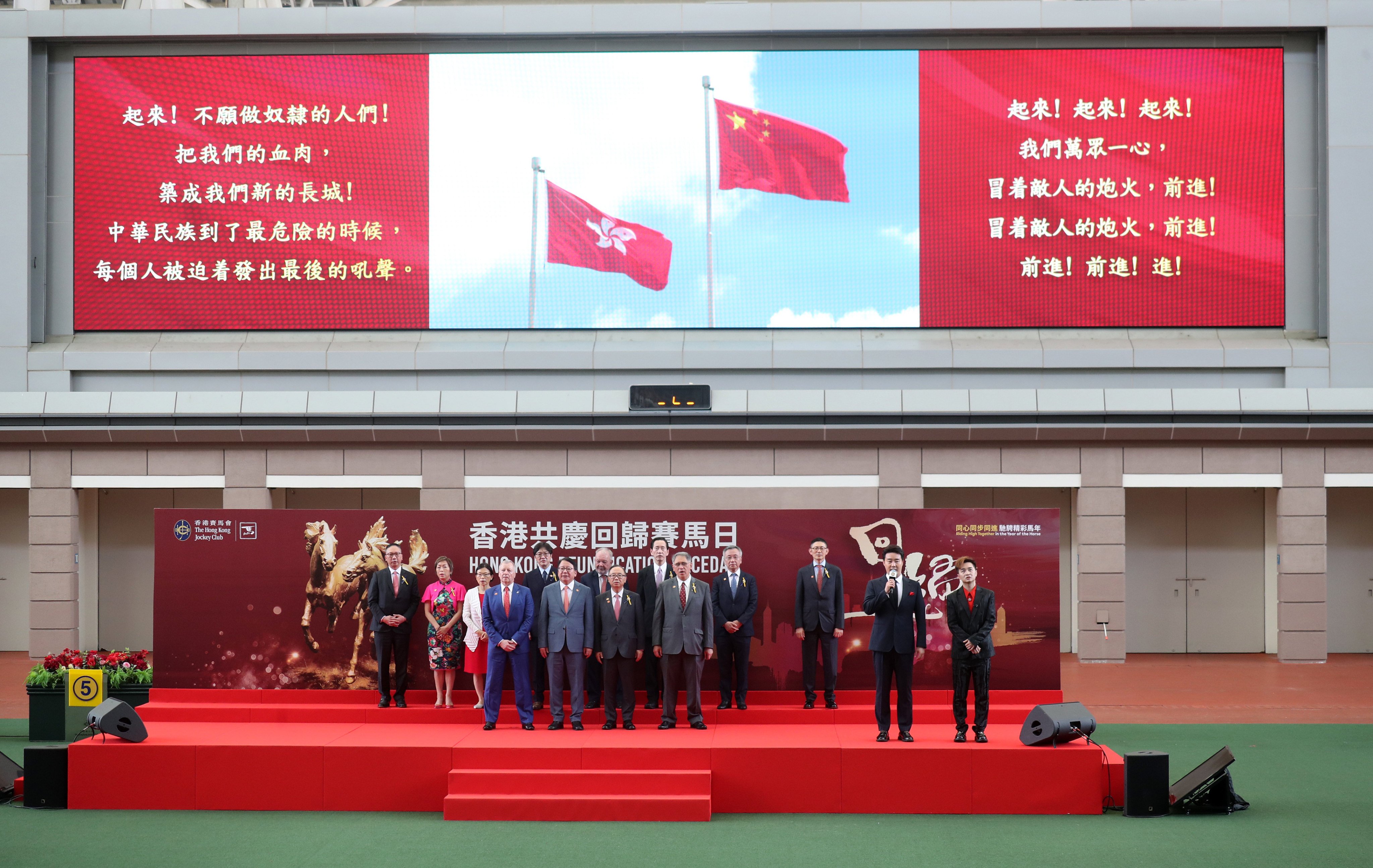 Zhang Yingxi (second from right) leads the singing of the national anthem during the opening ceremony of the Hong Kong Reunification Raceday at Sha Tin Racecourse. Photo: Kenneth Chan.