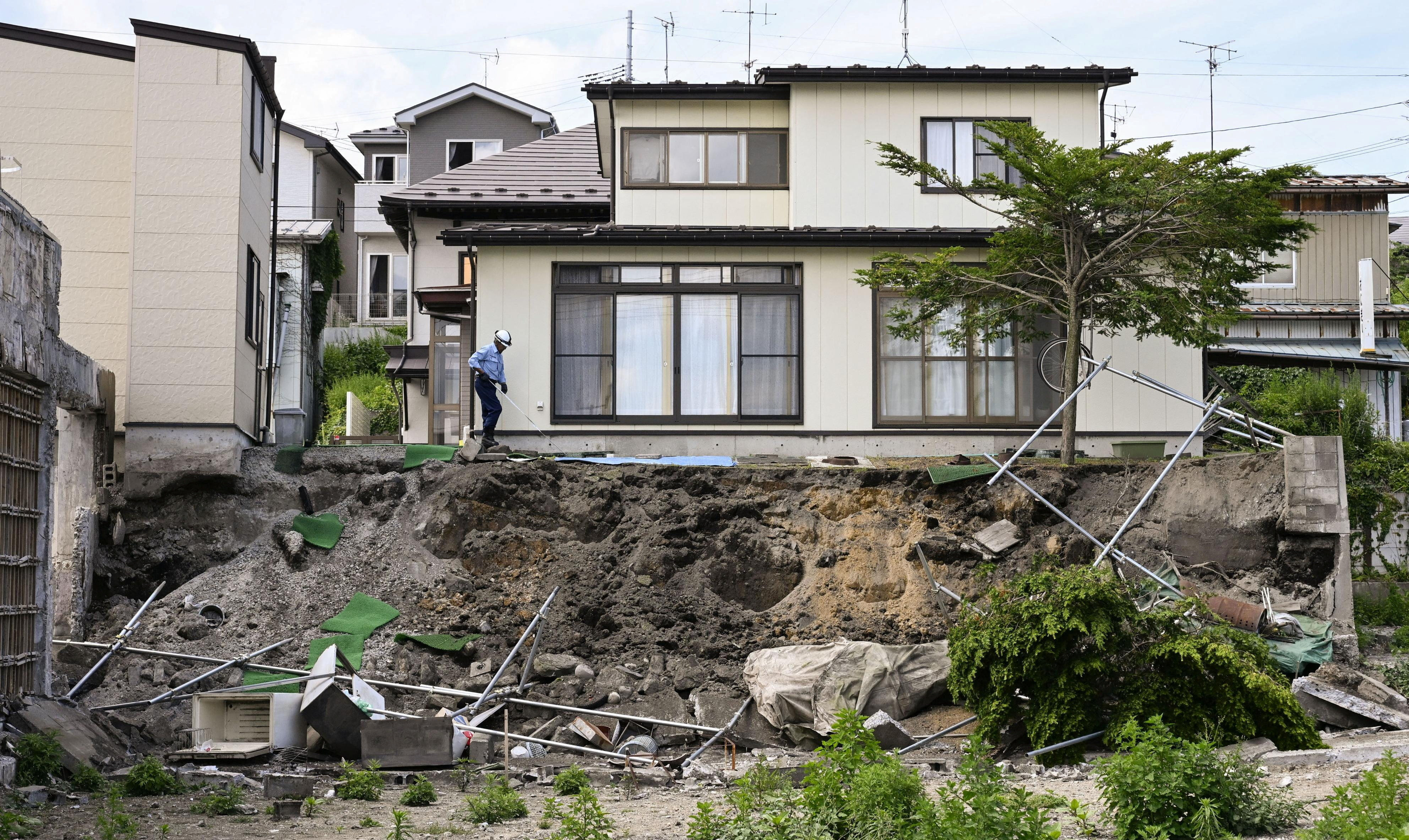 A man checks a retaining wall that collapsed by the earthquake in Hachinohe, Aomori prefecture, on June 25. Photo: Kyodo