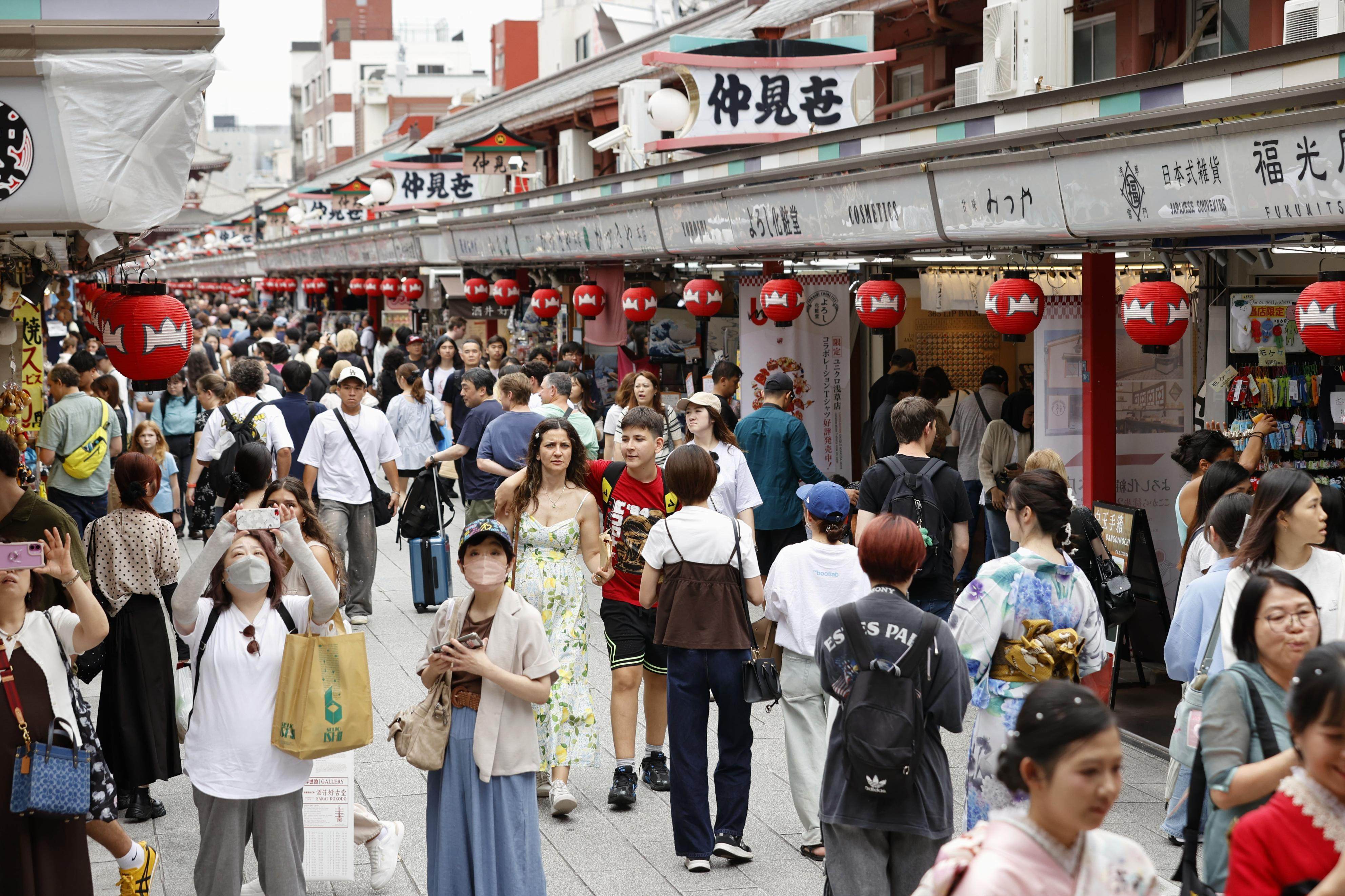 Tourists throng a shopping street in the popular Asakusa district of Tokyo on June 22. Photo: Kyodo
