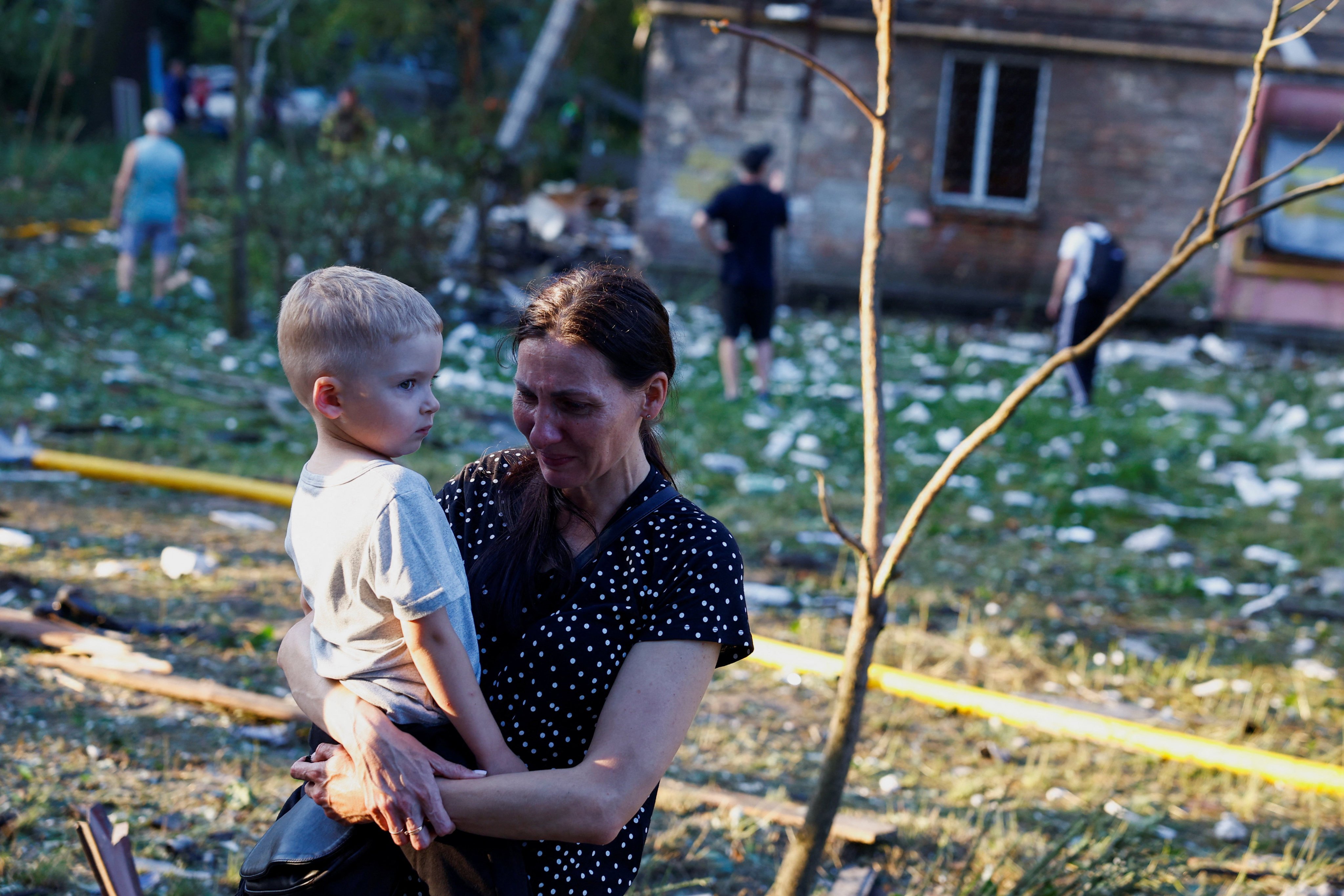 A woman cries holding a child. Photo: Reuters