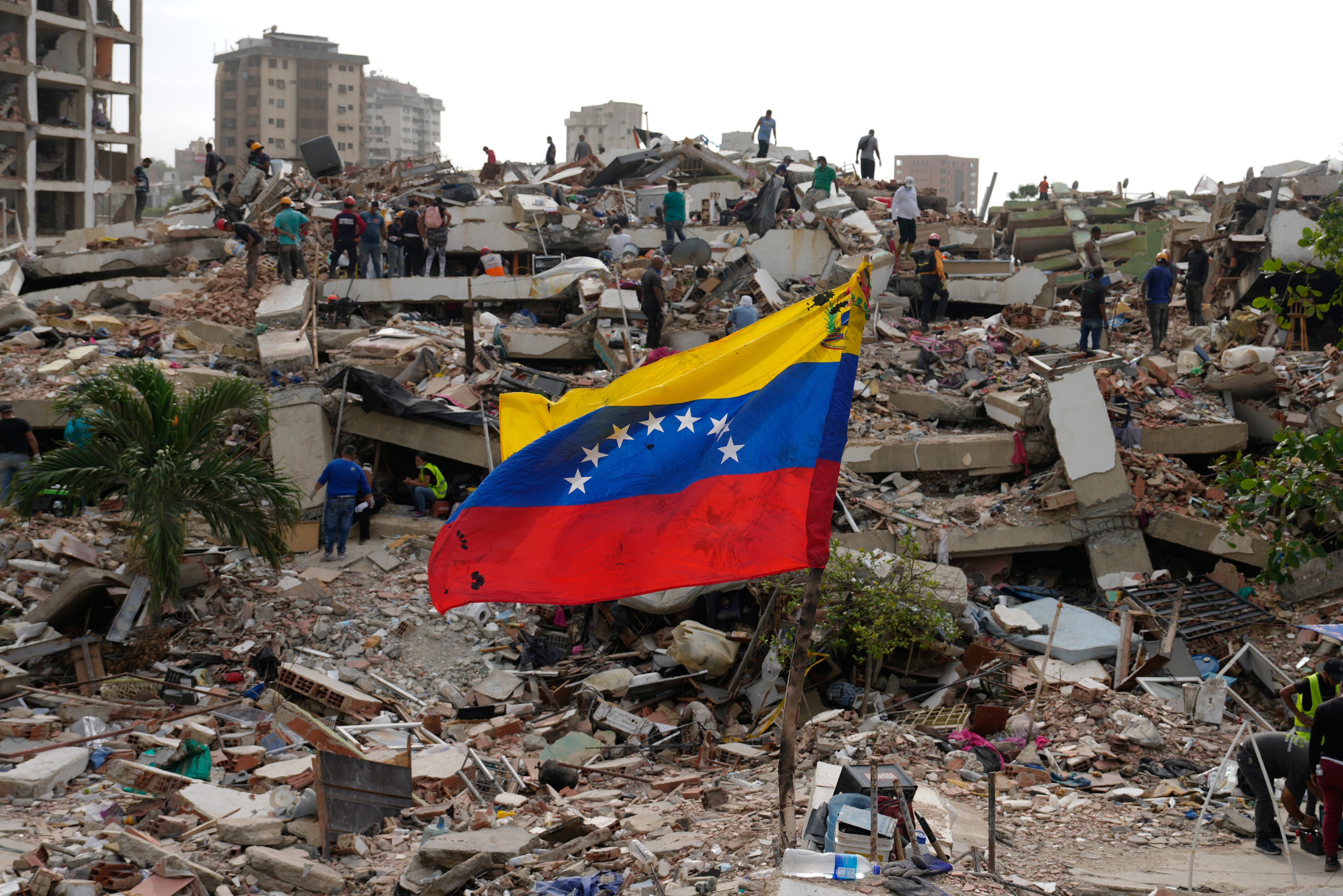 Residents and rescuers search through rubble. Photo: AP