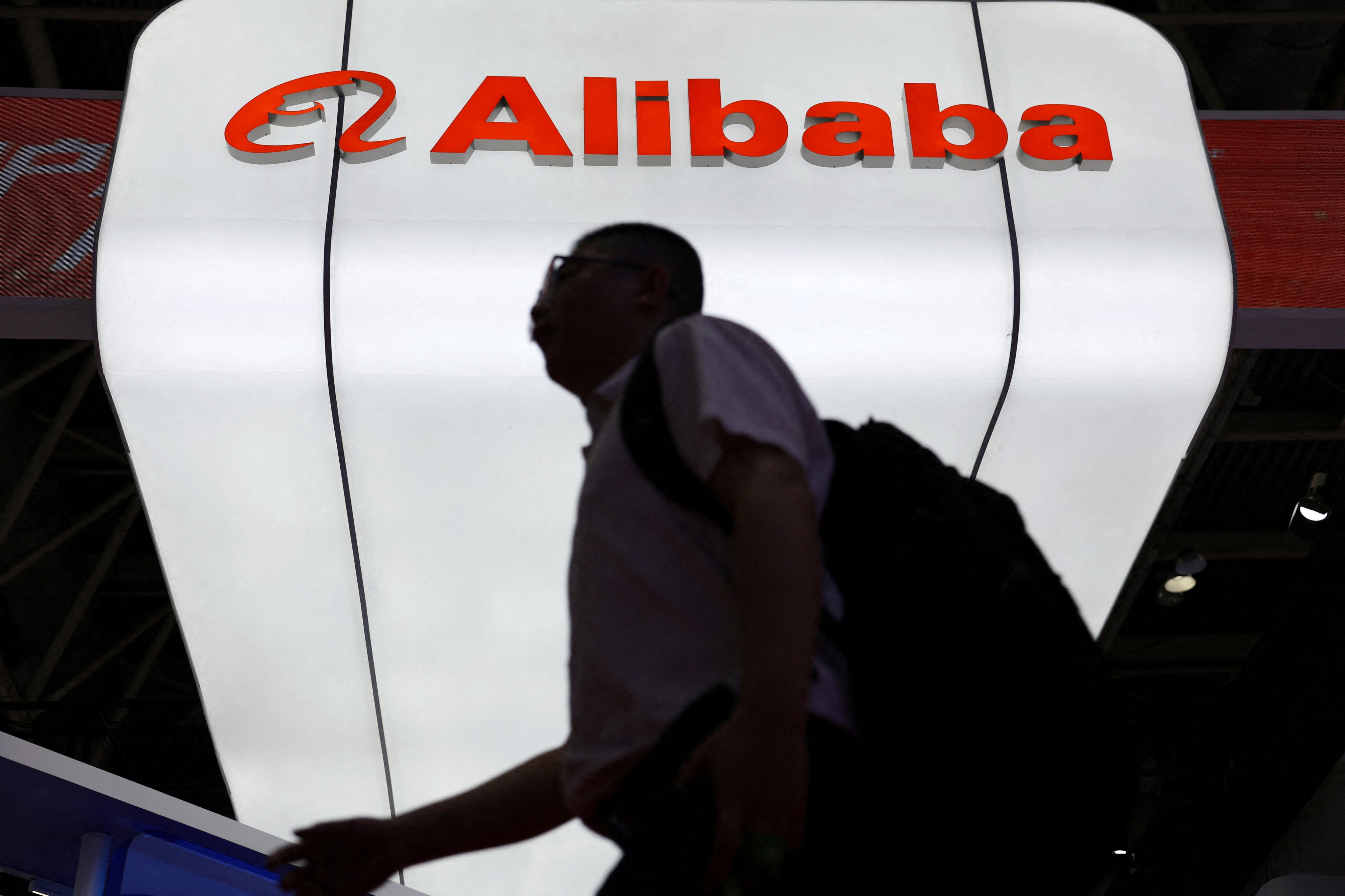 A man walks past the Alibaba Group Holding logo at a business expo in Beijing. Photo: Reuters