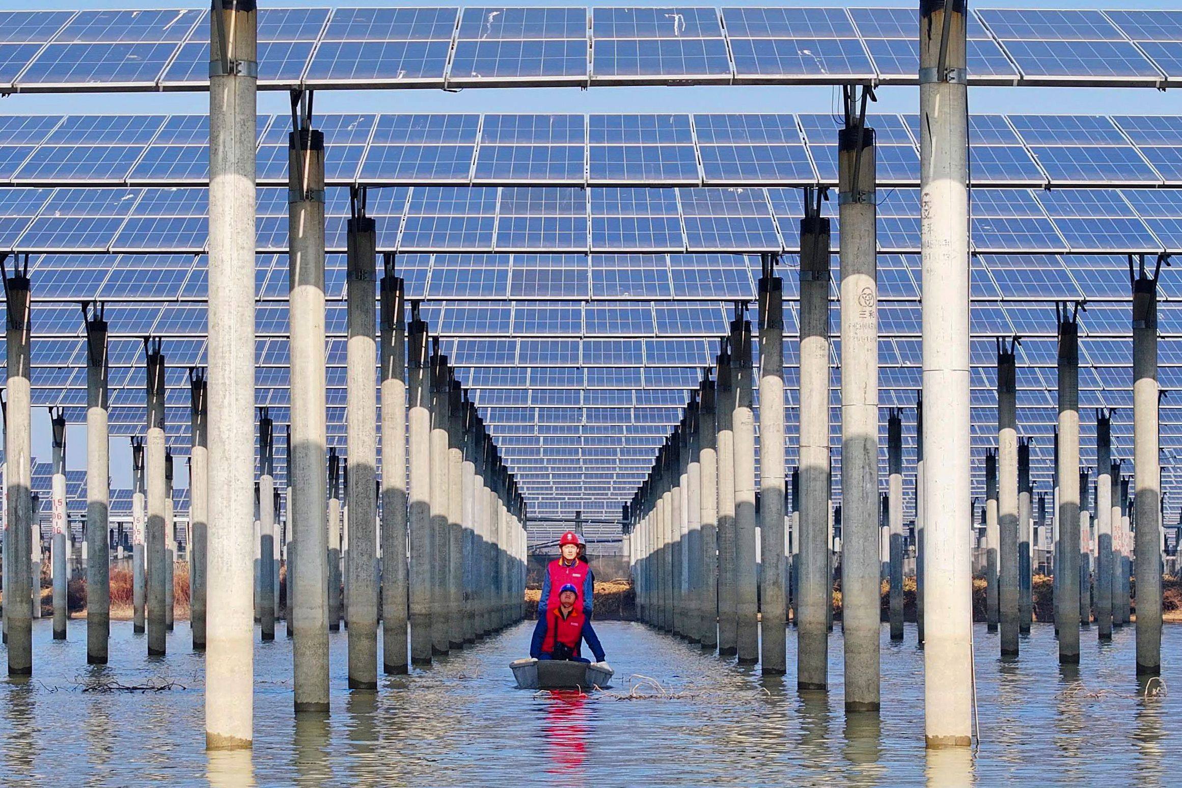Workers check solar panels installed over a lake in Tianchang, east China’s Anhui province on January 12. Cheap solar panels are not a climate problem; they are part of the climate solution. Photo: AFP