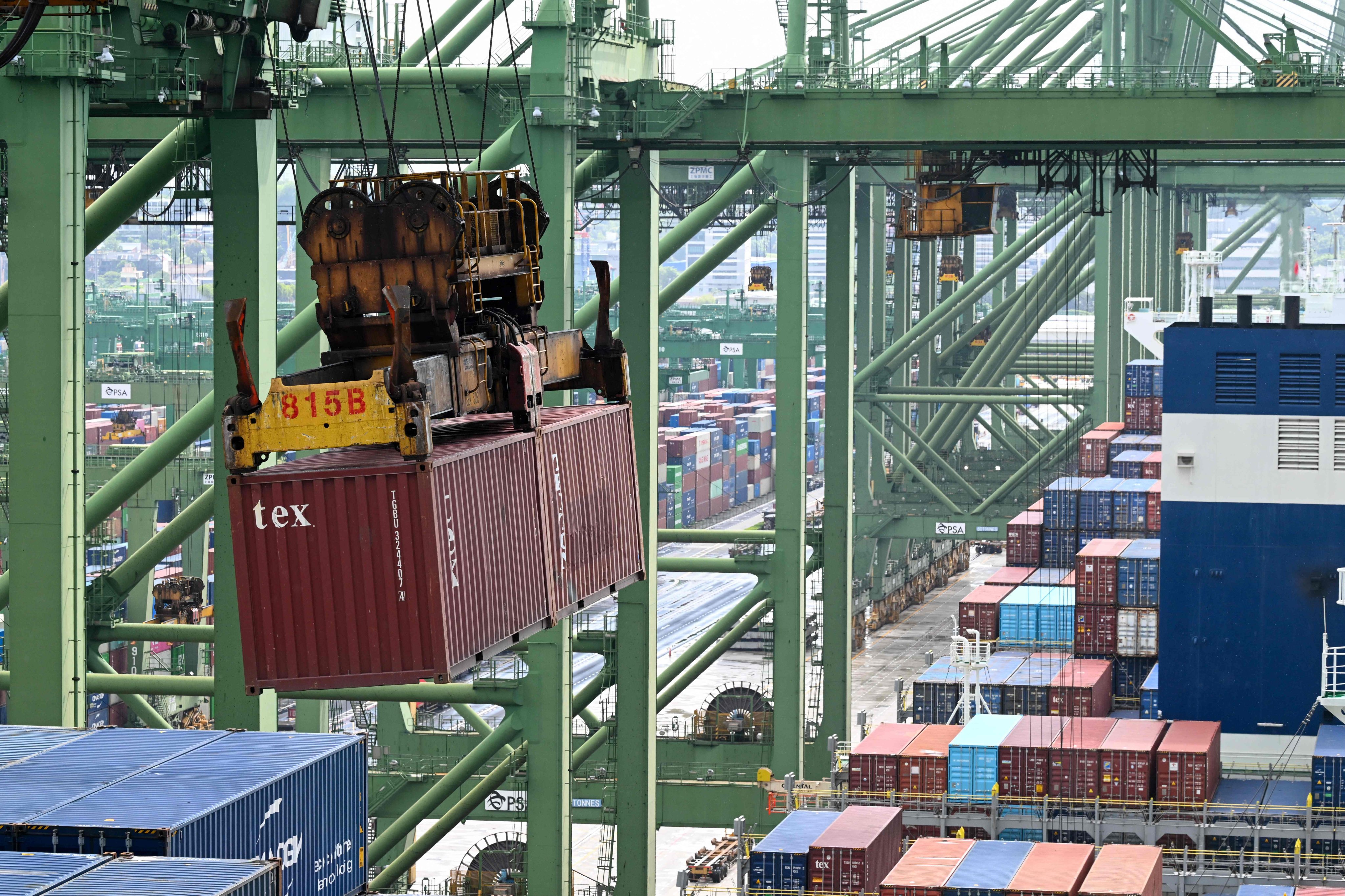 A crane loads a container onto a ship at a terminal in Singapore. Photo: AFP