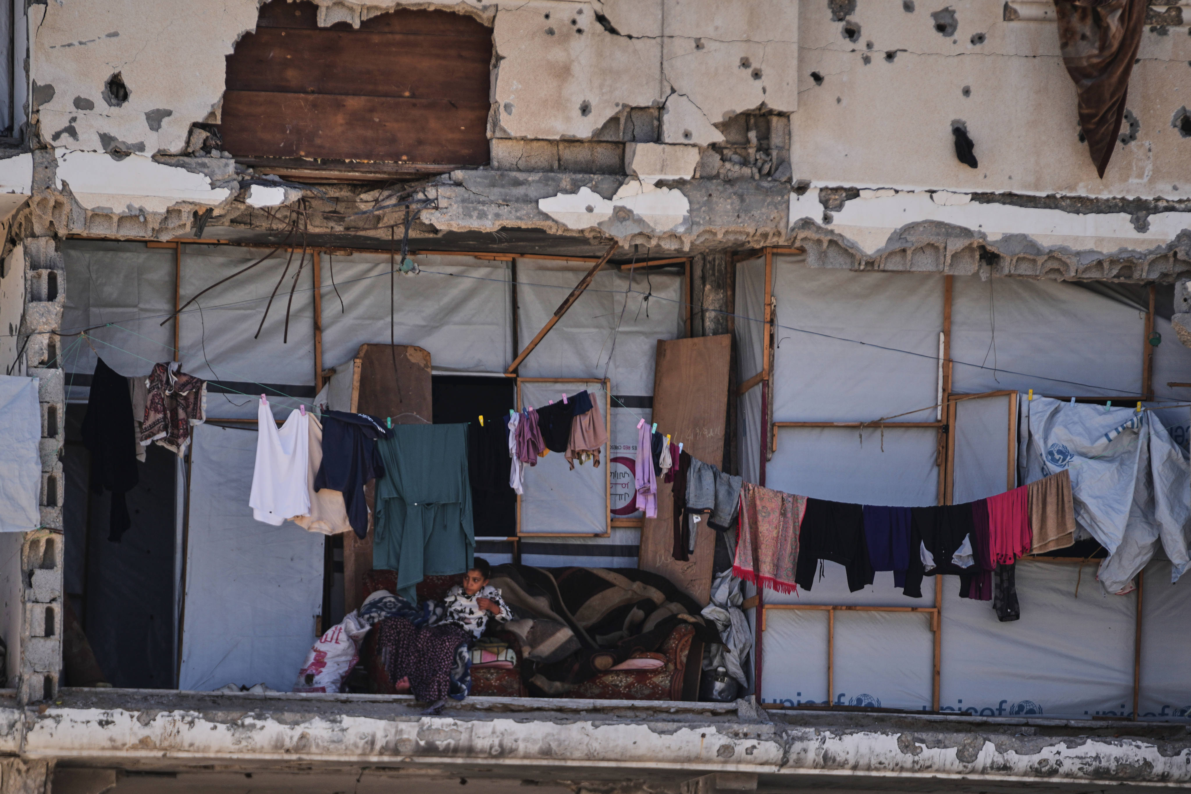 A Palestinian girl sits inside a house damaged during the Israel-Hamas war in Khan Younis, southern Gaza Strip, on Wednesday. Photo: AP