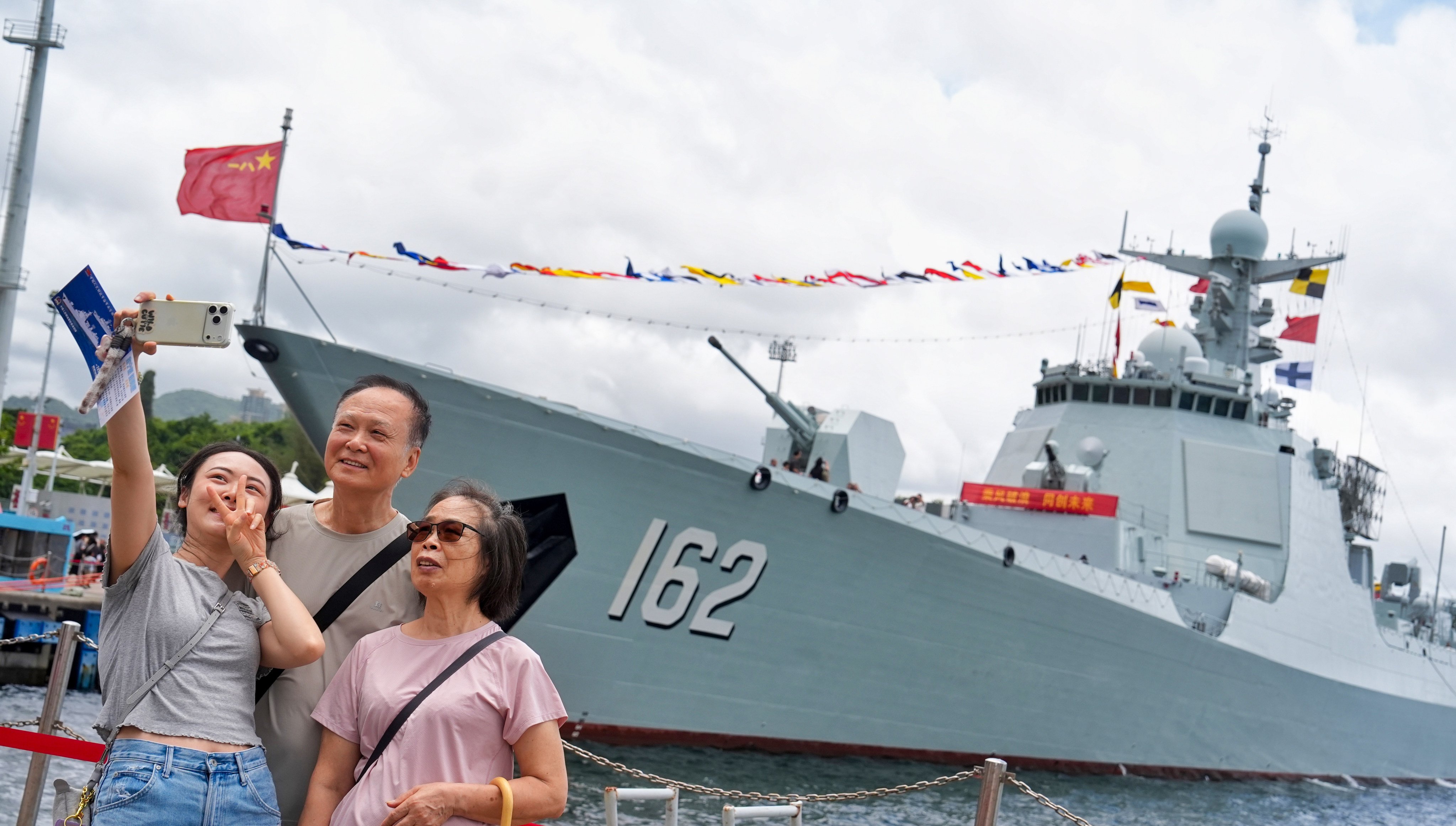 People pose for pictures with two PLA Navy vessels at Ngong Shuen Chau Barracks on July 4. Photo: Elson Li