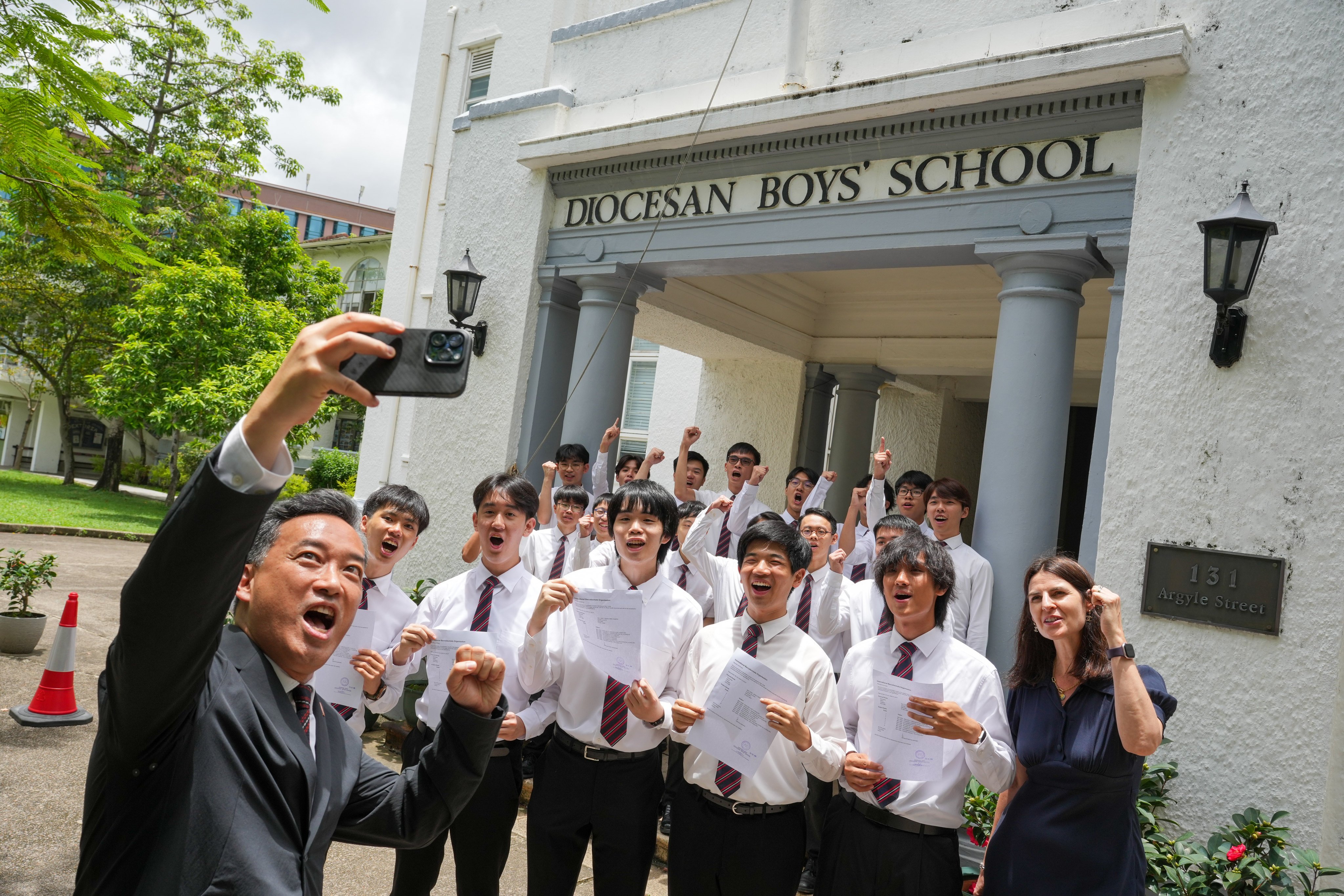 DBS headmaster Ronnie Cheng takes a selfie with perfect-score students (front row, from left) Lucas Chavez, Adrian Lee, Jordan Wong, Evan Chow, and Kyle Leung, while IB programme coordinator Katherine Dutton raises her fist in celebration. Photo: May Tse