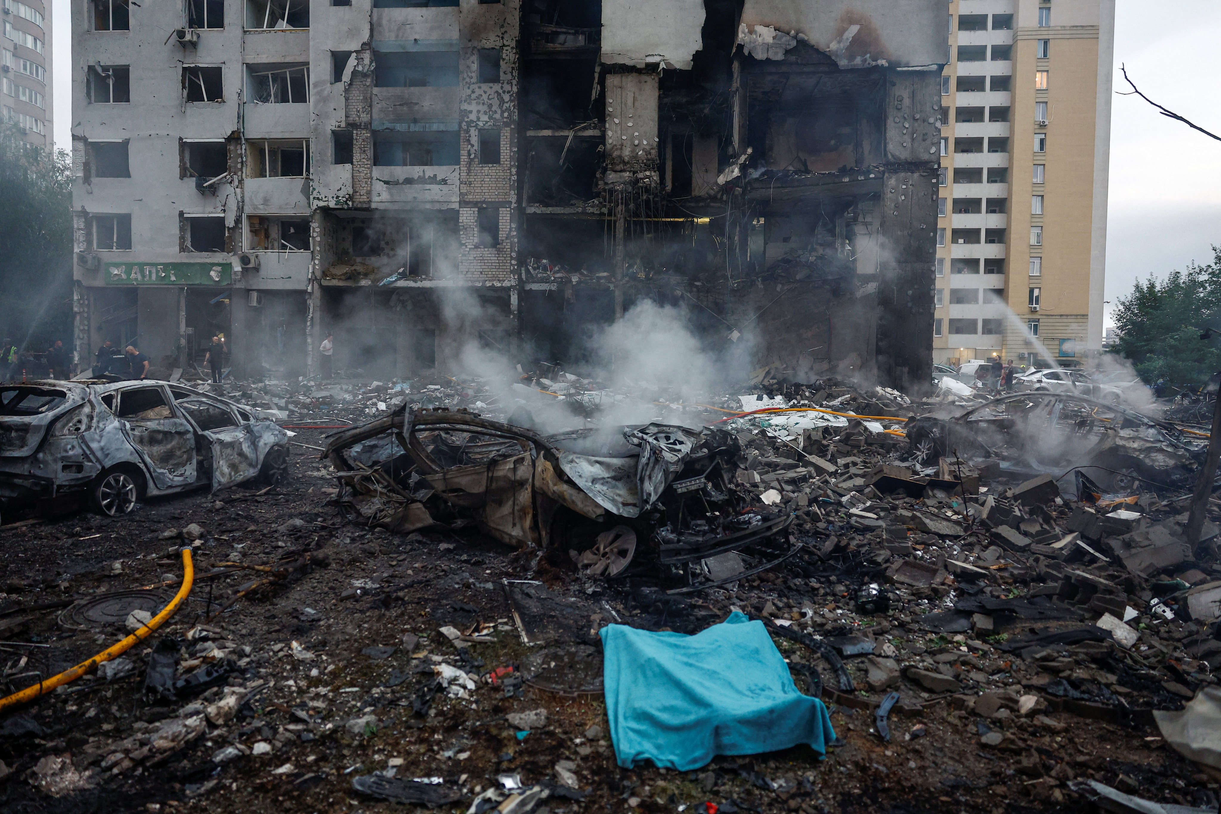 A covered body in front of a residential building in Kyiv. Photo: Reuters