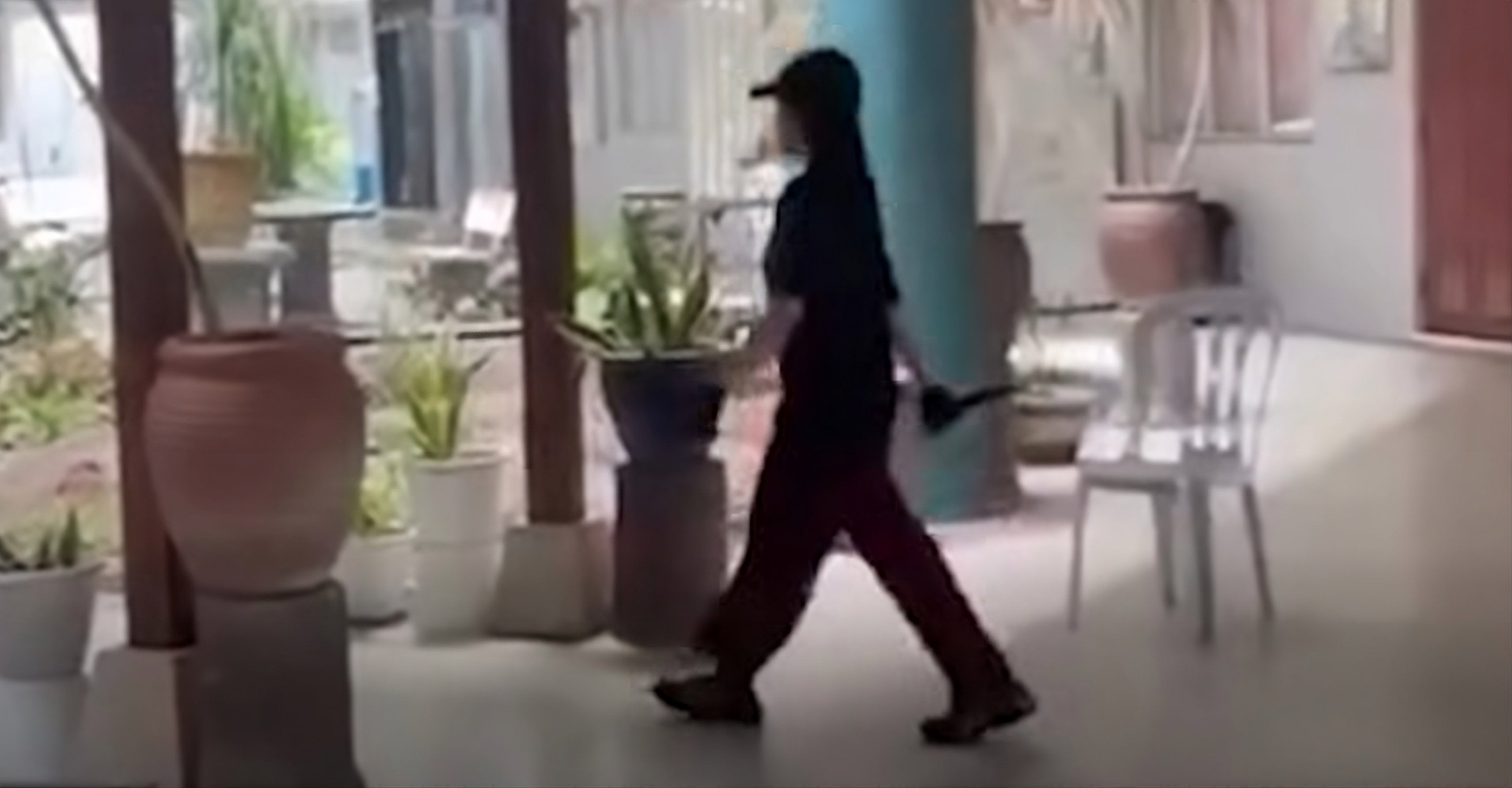 A still from a social media video shows a girl dressed in black walking around the school while holding a knife after the stabbing in Banting, Malaysia, on Monday. Photo: The Star