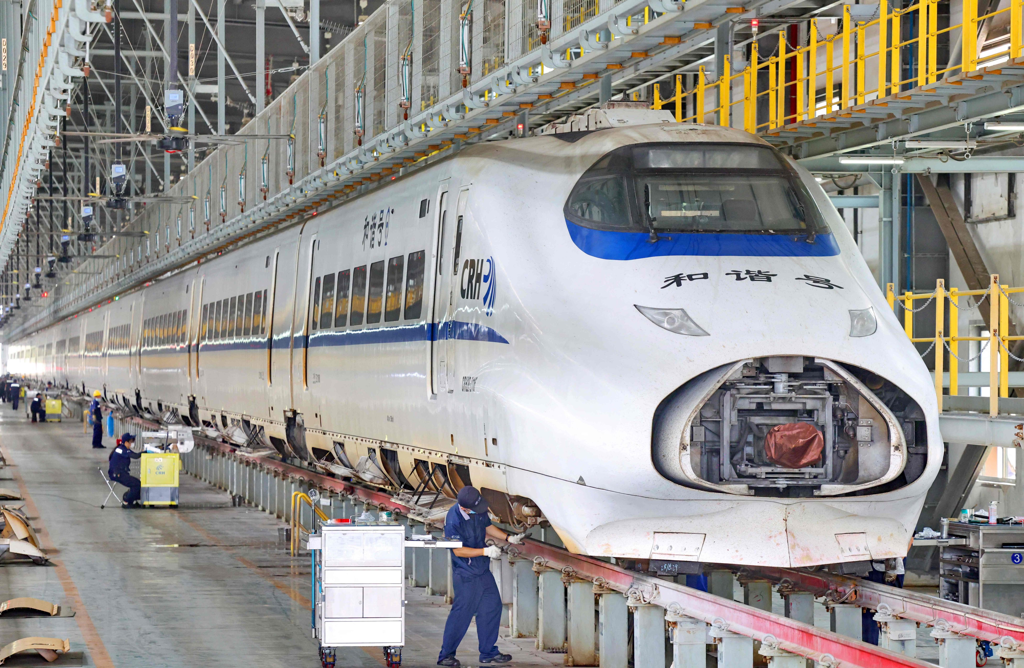 Workers examine a high-speed train at a depot in Nantong, in eastern Jiangsu province, on June 29. Photo: AFP