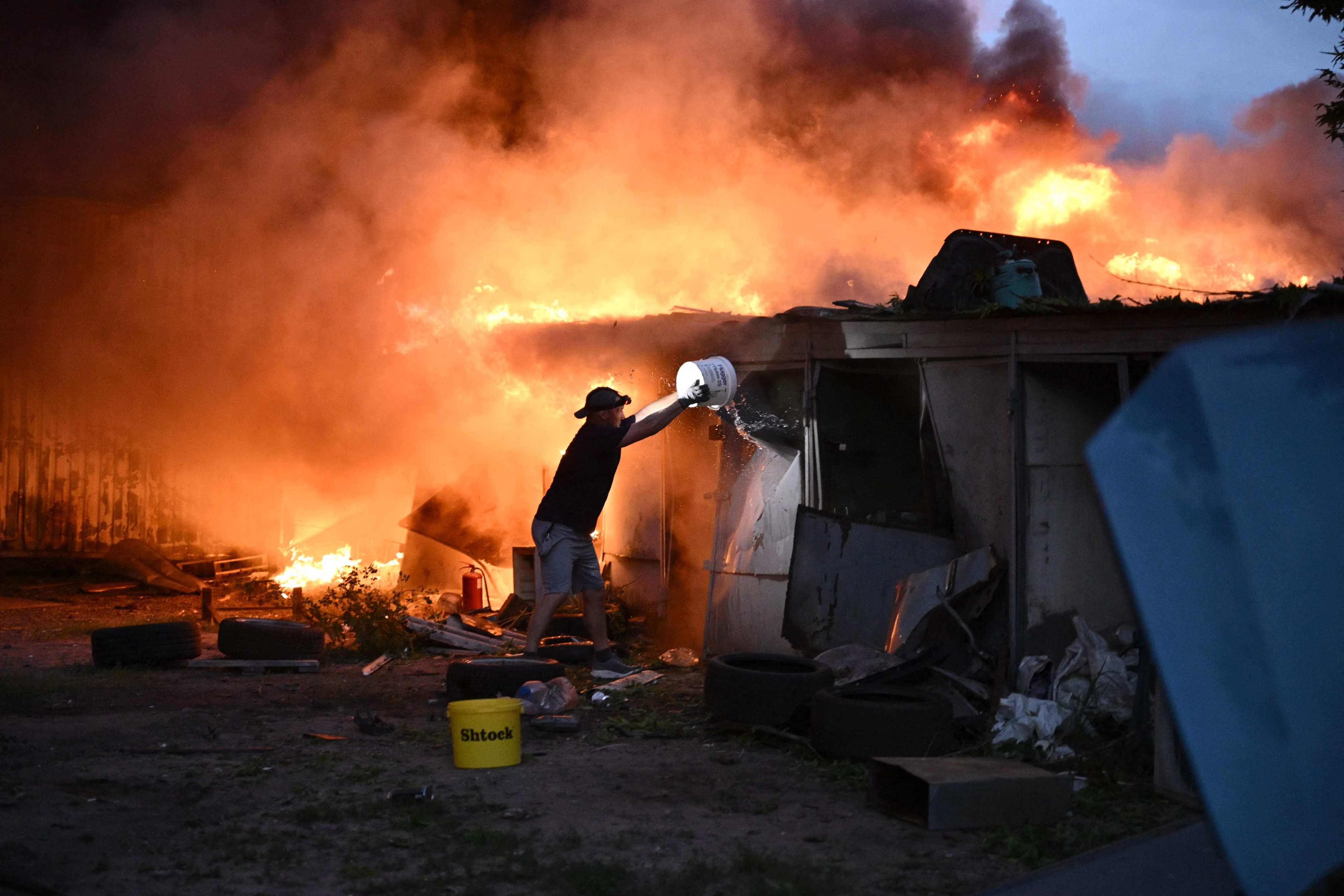 A resident tries to extinguish a blaze. Photo: AFP