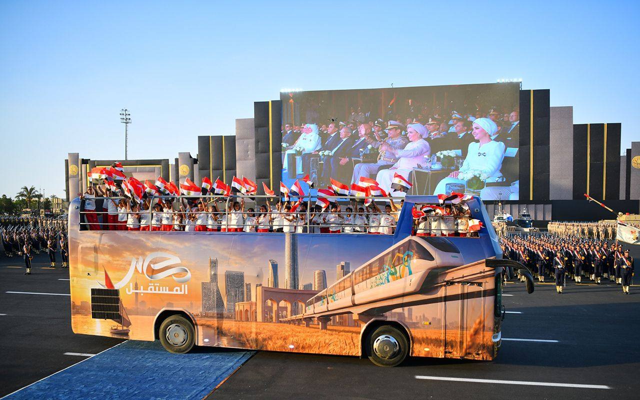 An open-top bus carrying a group of children passes The Octagon military headquarters near Cairo, Egypt. Photo: Egyptian Presidency / dpa