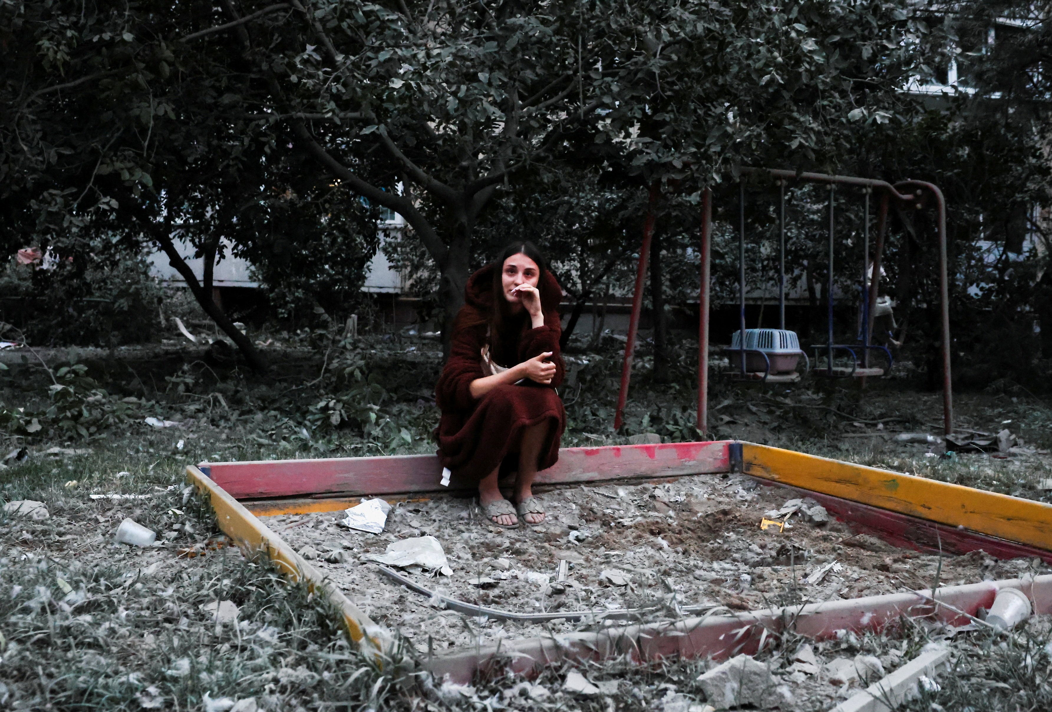 A woman who fears her friend is under the rubble of a building in Kyiv. Photo: Reuters
