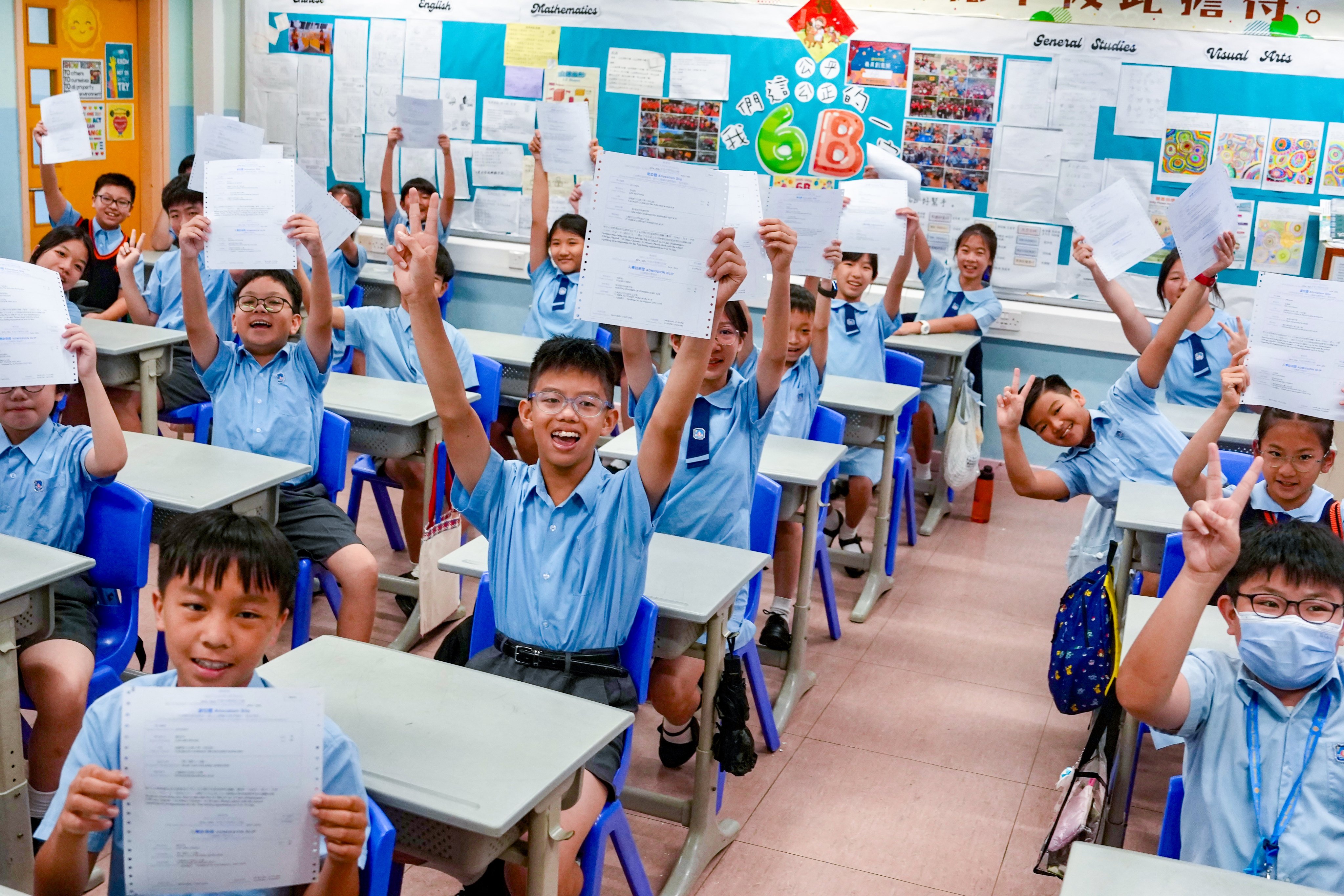 Primary Six students at Yaumati Catholic Primary School (Hoi Wang Road) hold up their secondary school allocation results. Photo: Sam Tsang