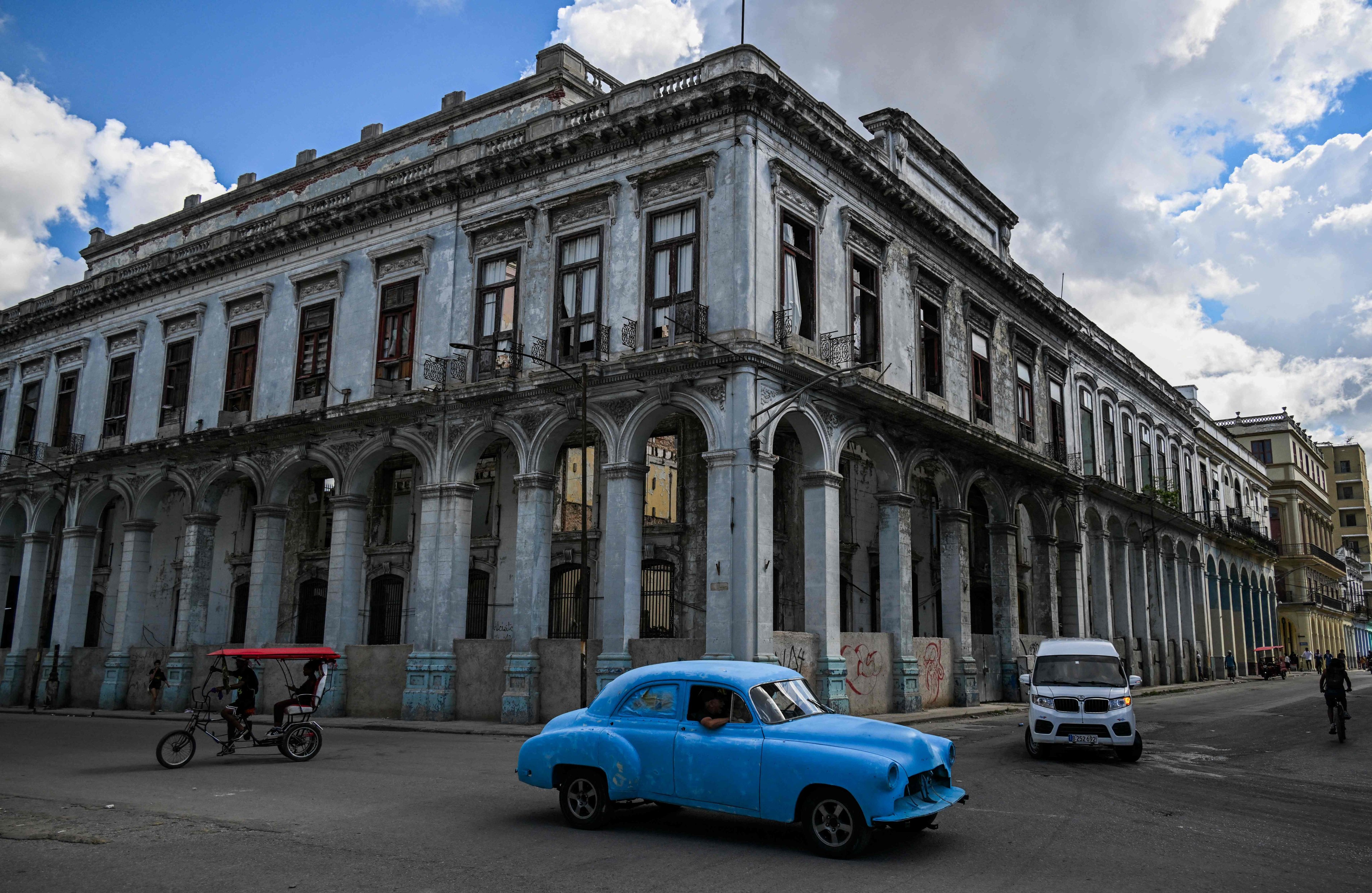 An old US car drives past a building at risk of collapse in Havana. Photo: AFP