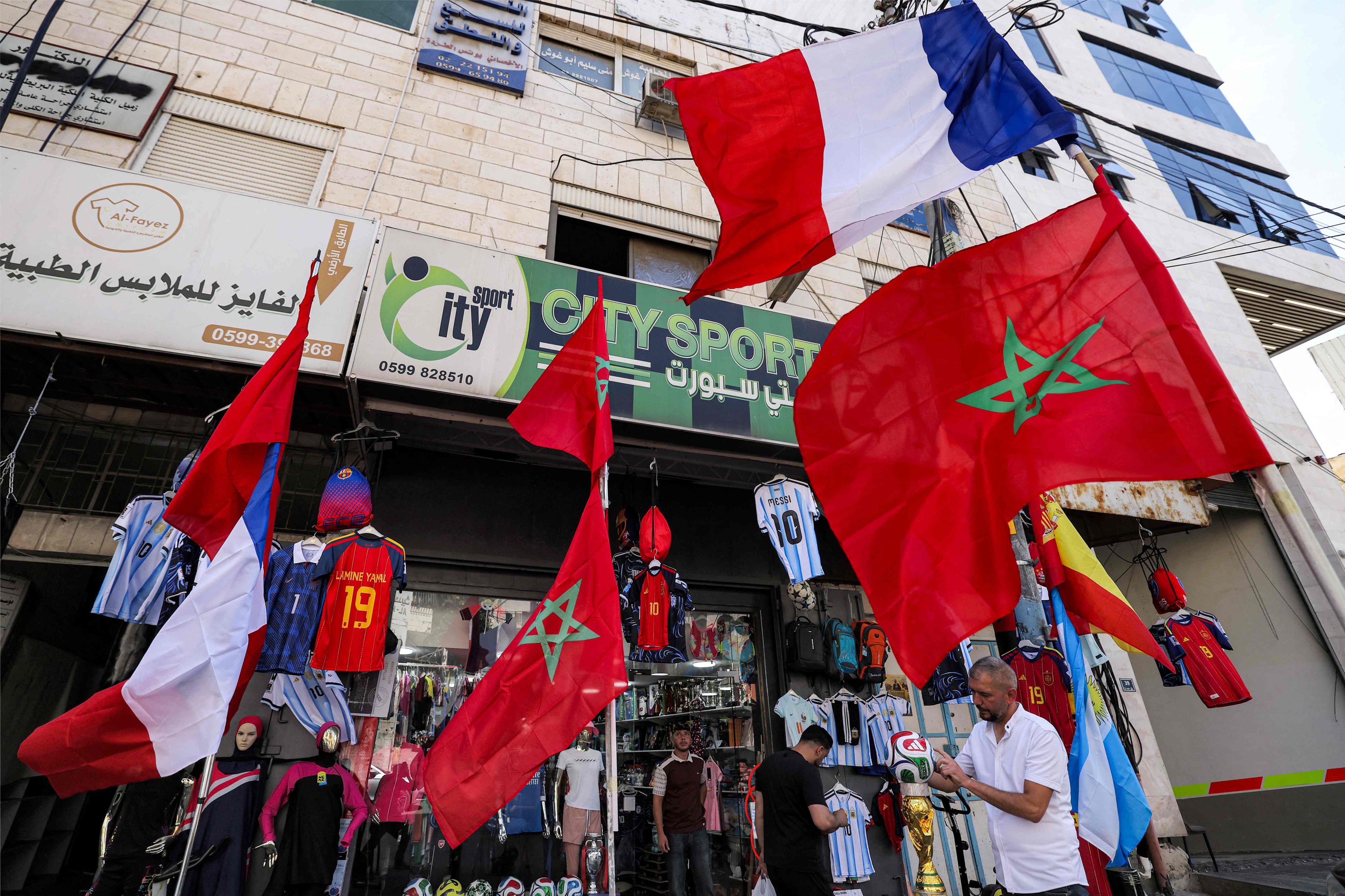 Moroccan and French flags, and jerseys with the names of Lionel Messi and Spain's Lamine Yamal, outside a sports shop in Hebron in the occupied West Bank on Wednesday. Photo: AFP