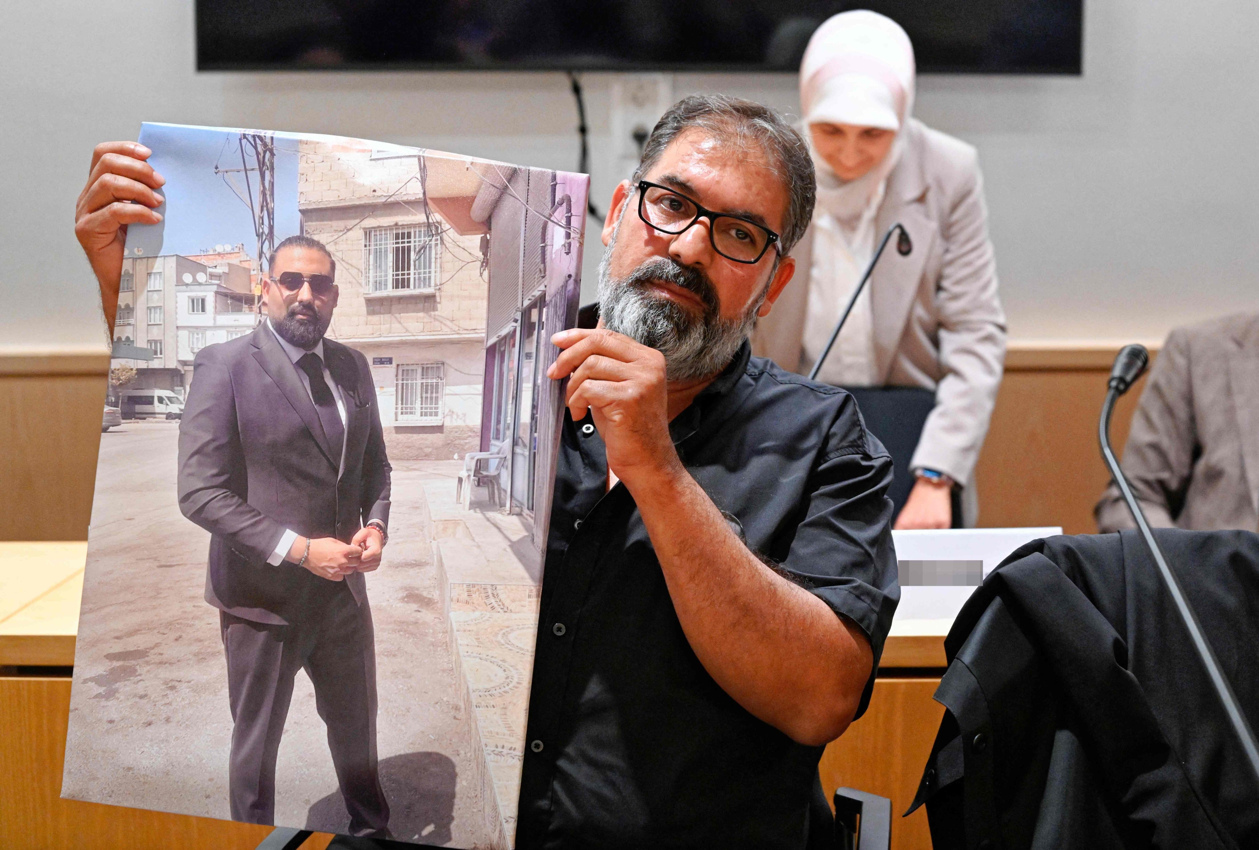 Erdal Calar, father of the dead train attendant Serkan Calar, holds a picture of the victim in the courtroom of the Regional Court of Zweibruecken, western Germany last month. Photo: AFP
