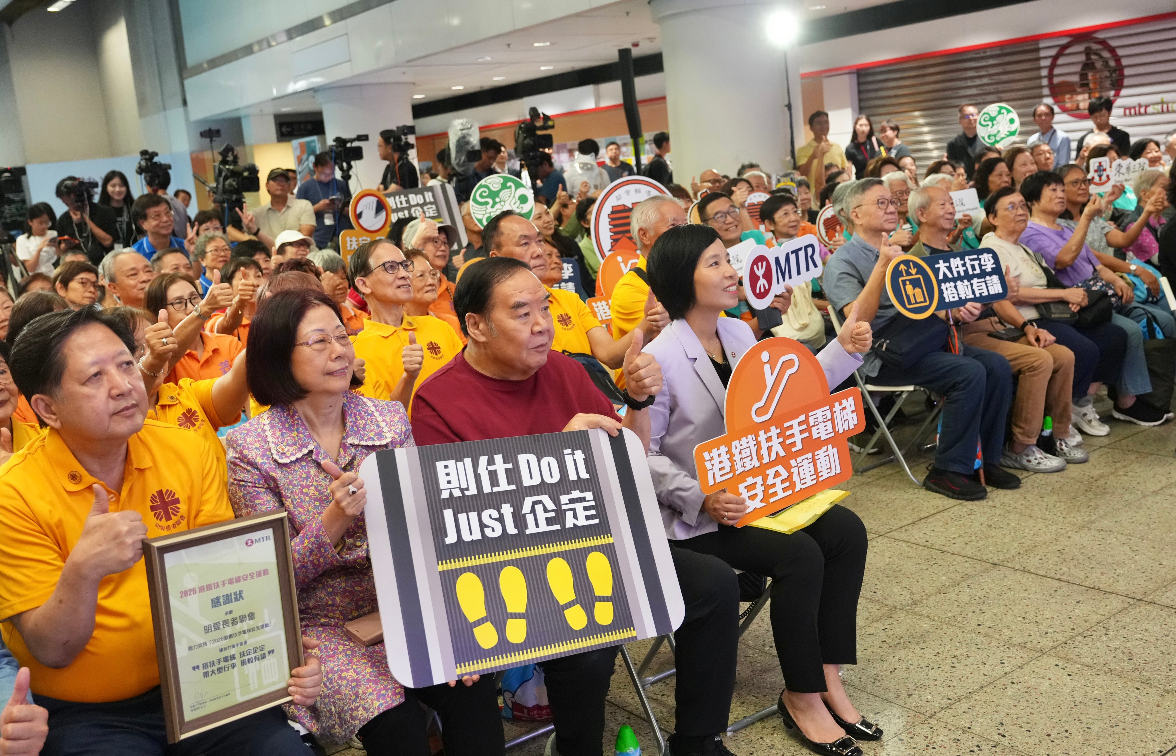 Kent Cheng (third from left) and Cheris Lee (fourth from left), deputy director of the operating and metro segment, with other MTR Corp staff and passengers at the launch of the promotional campaign at Hung Hom station. Photo: Karma Lo.