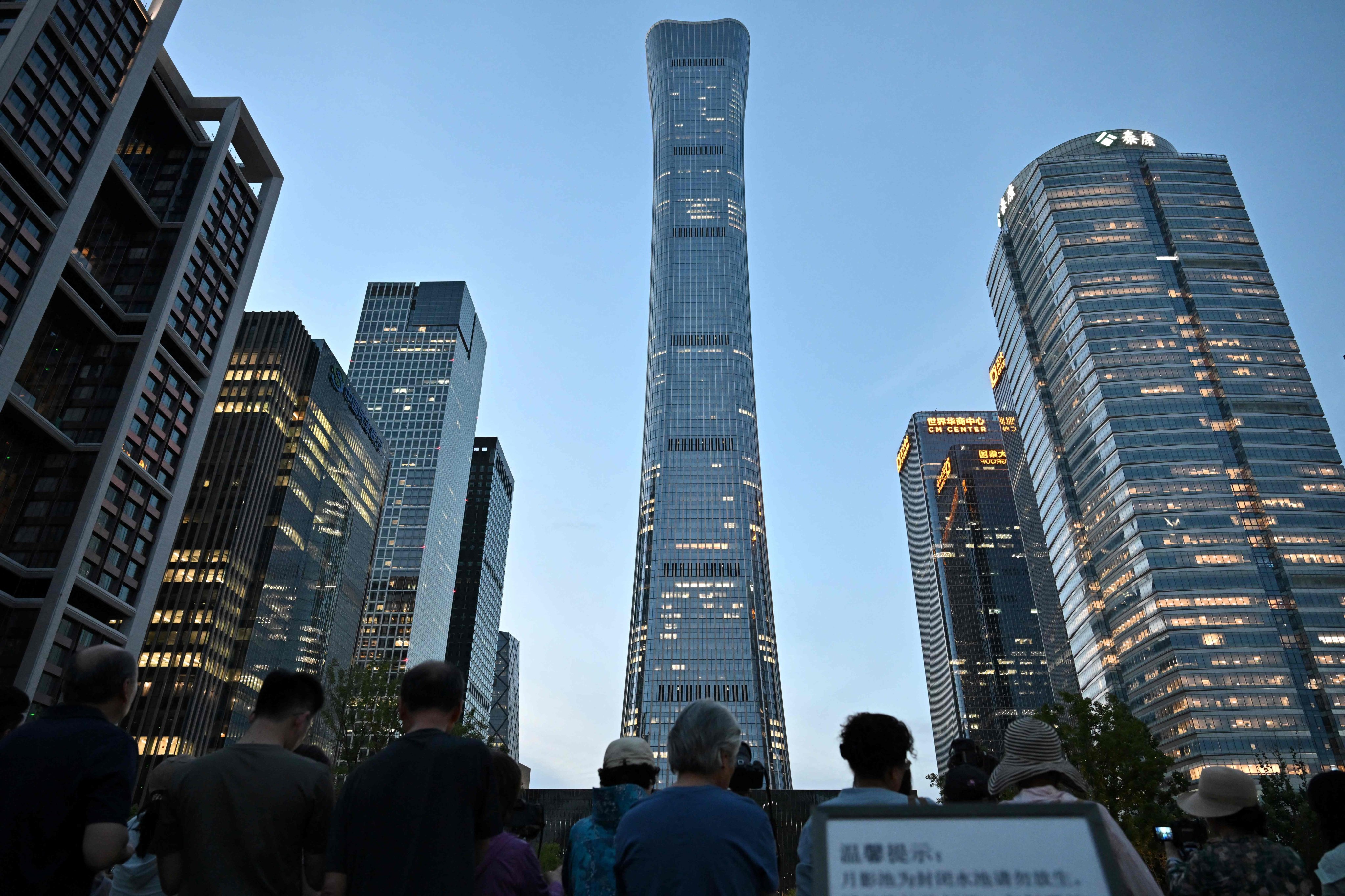 People gather near the Citic Tower in Beijing on June 26 after a small plane struck the building. Photo: AFP