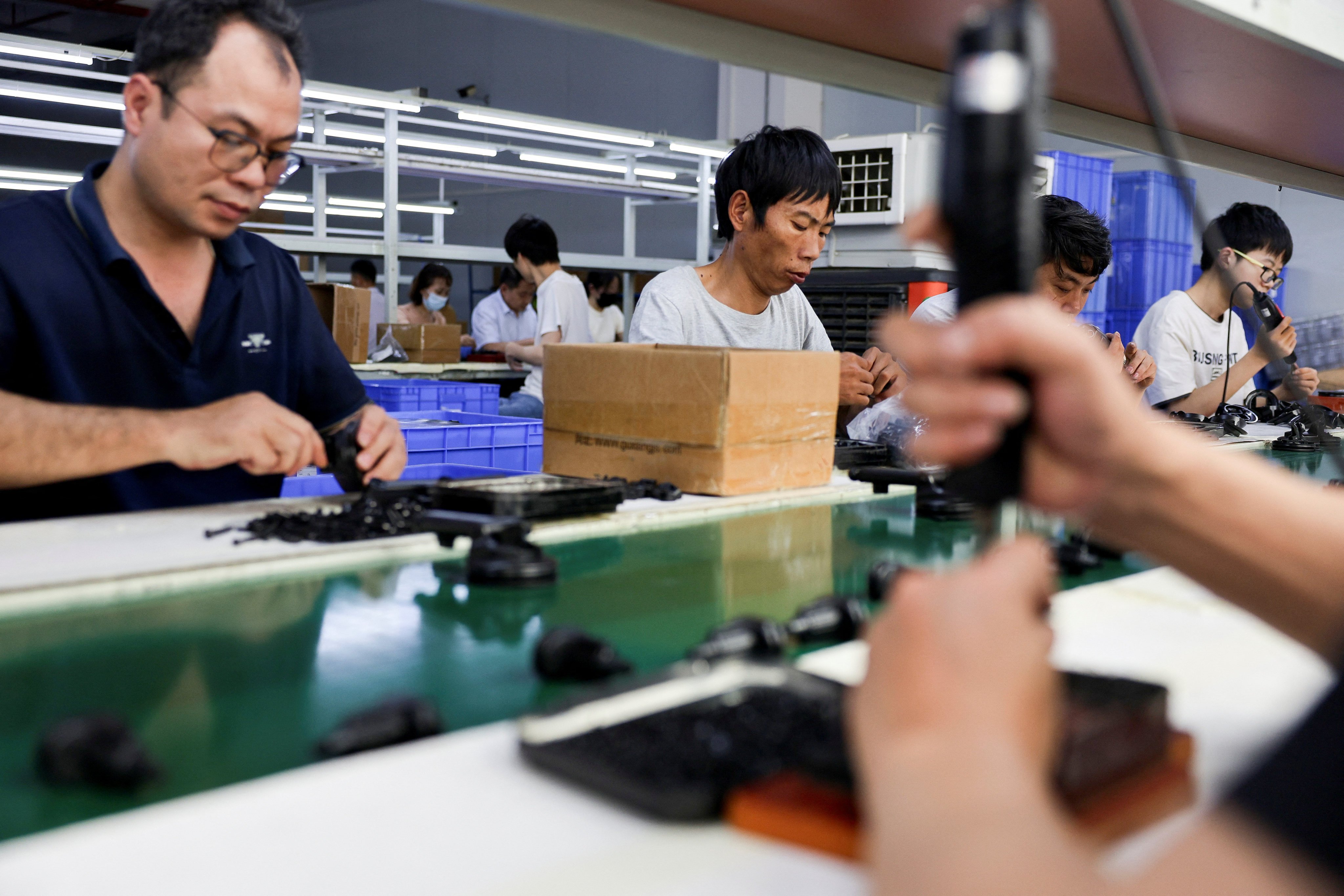 People assemble car smartphone holders at a plastic accessories factory in Dongguan, Guangdong province, in April. Photo: Reuters