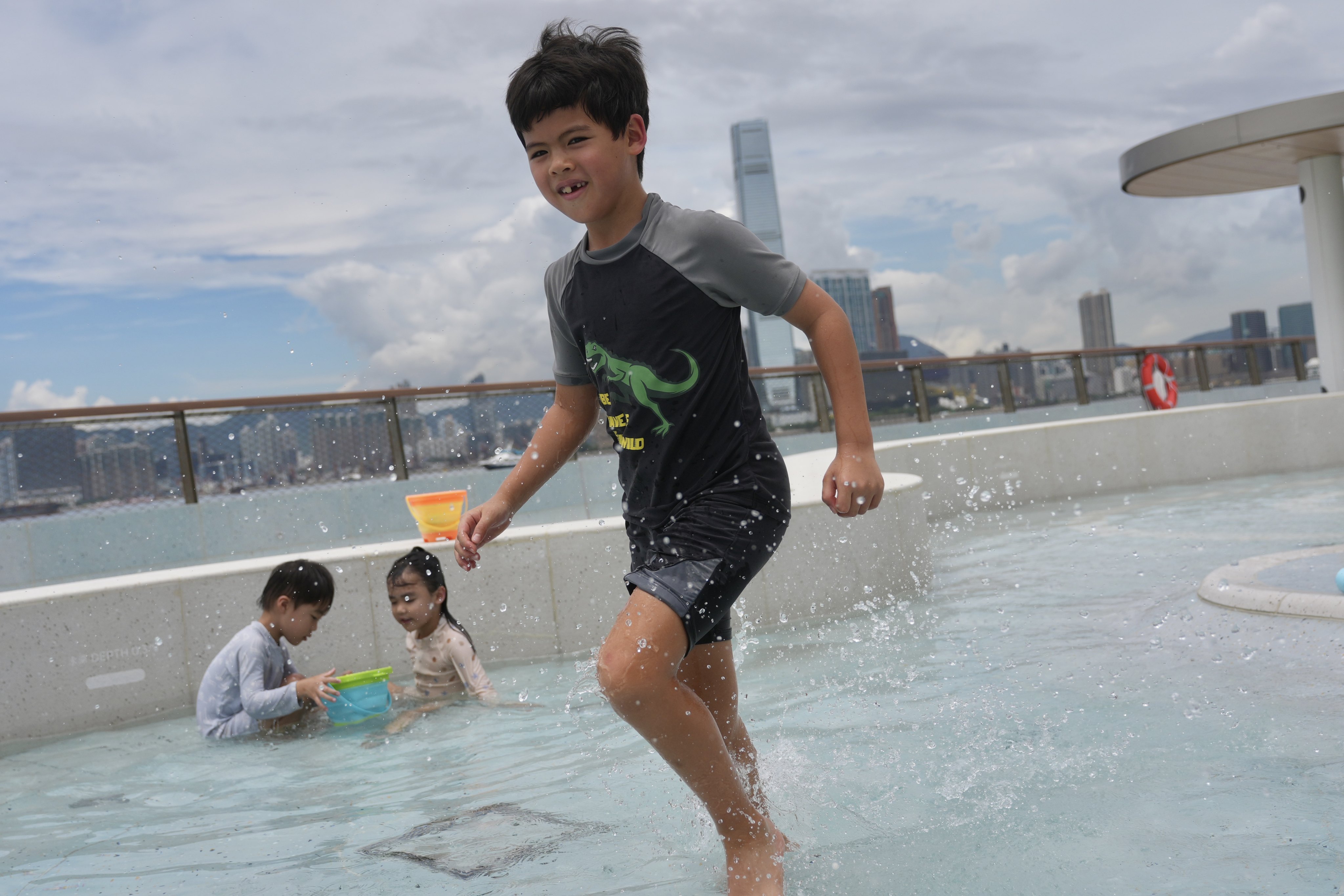 Children cool off in a shallow water play pool amid the heat on Friday. Photo: Karma Lo