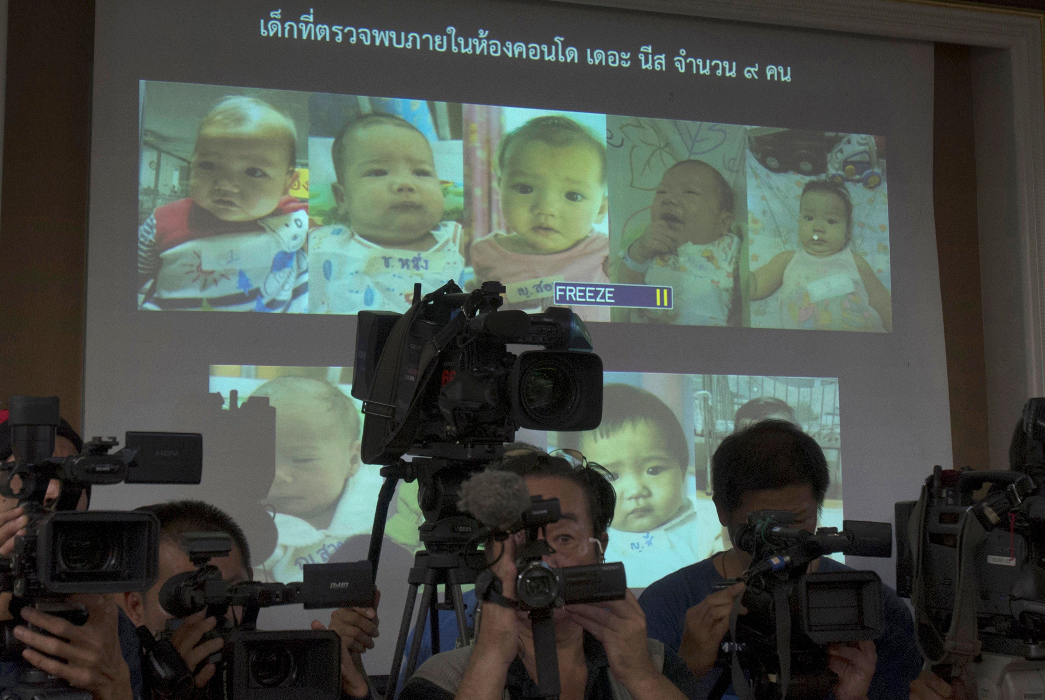 Media attend a press briefing where Thai police showed pictures of surrogate babies in 2014, the year before Thailand banned commercial surrogacy. Photo: AP