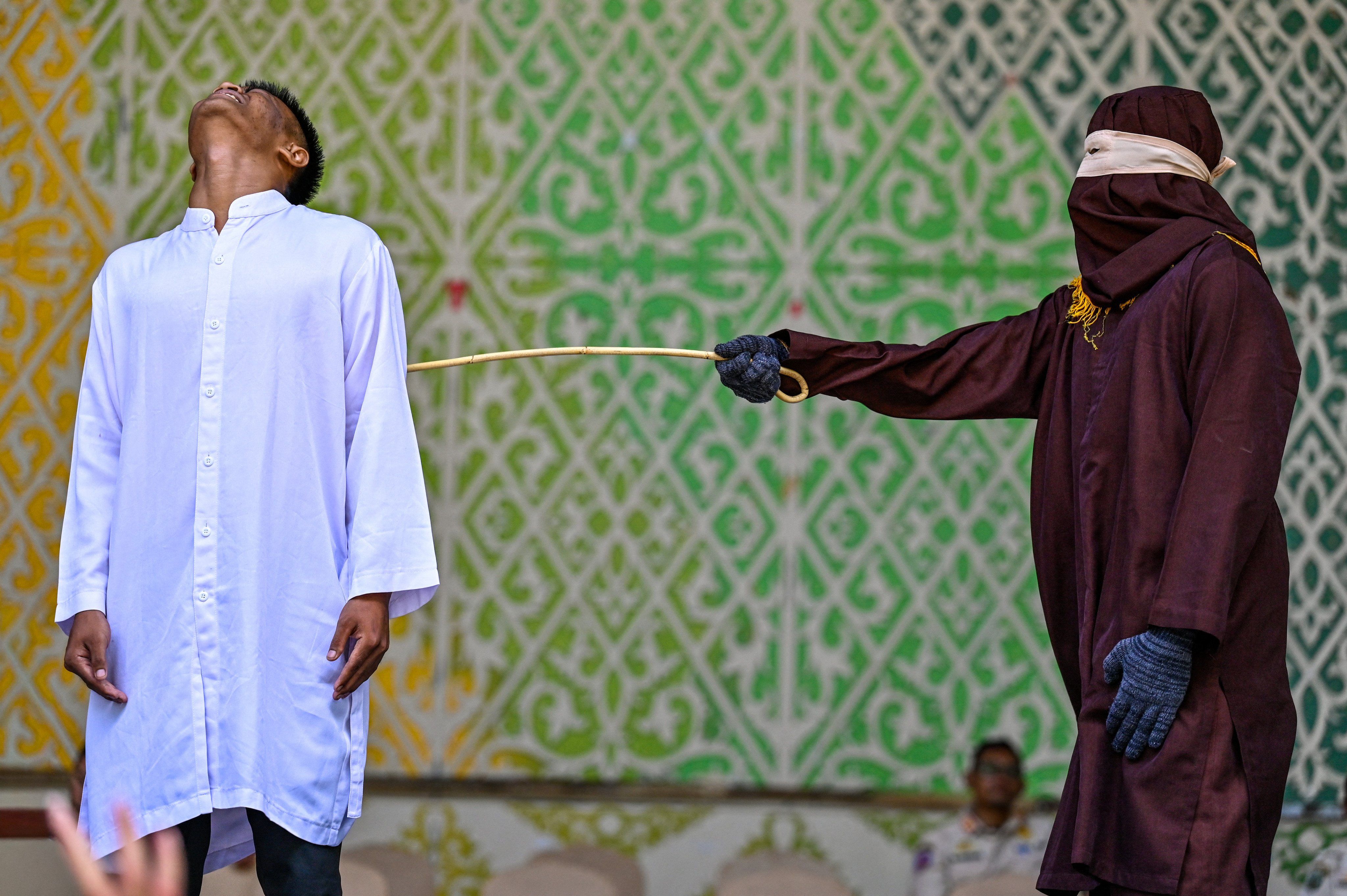 A man convicted of having sex outside marriage receives 100 lashes from a member of the sharia police during a public caning in Banda Aceh, Indonesia, on May 21. Photo: AFP