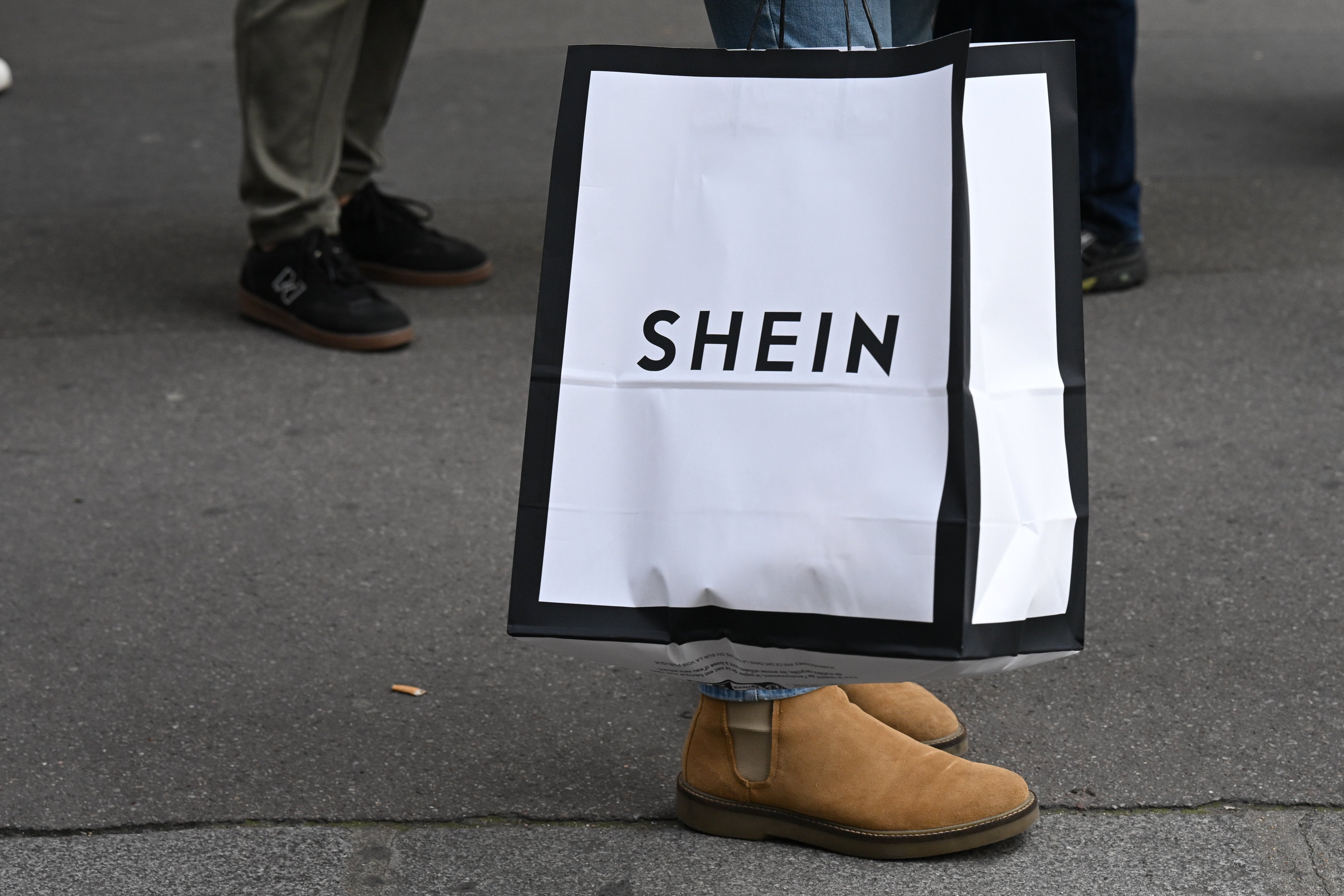 Customers carrying bags of shopping leave the Shein store in Paris in November. Photo: dpa