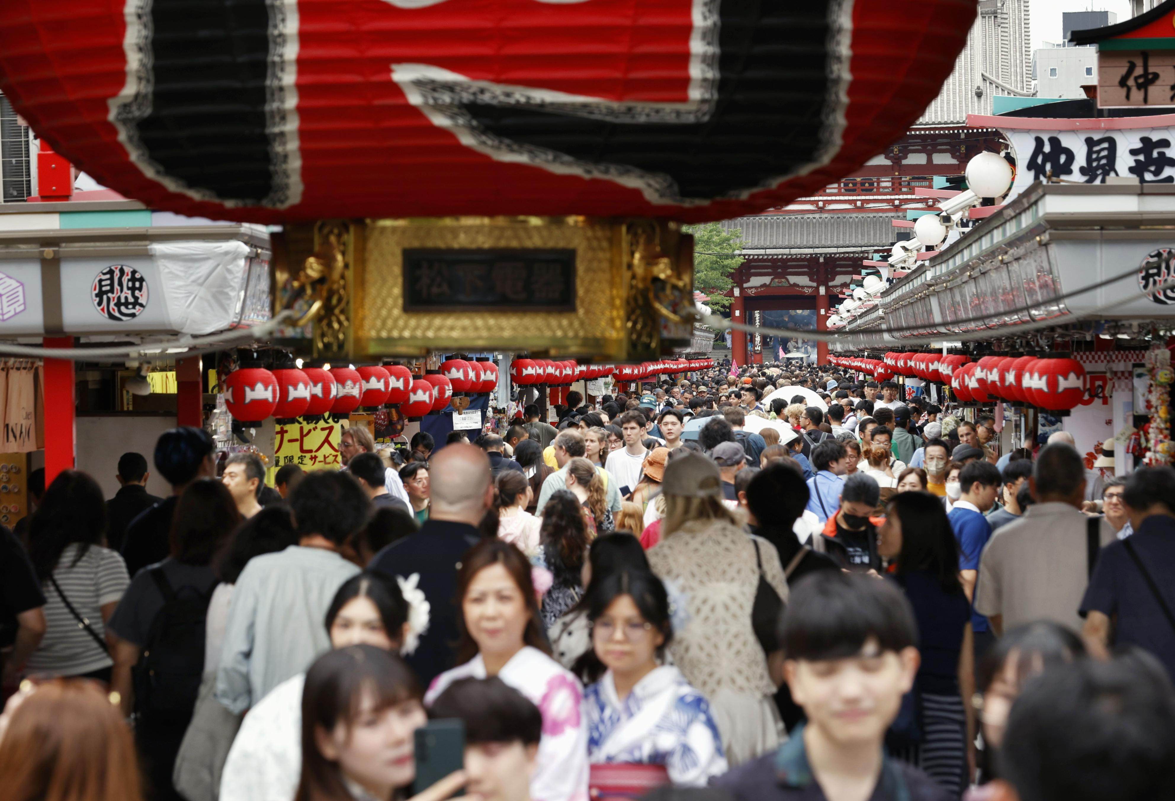 Tourists throng a shopping street in front of Sensoji Temple in the popular Asakusa district of Tokyo, Japan, last month. Photo: Kyodo