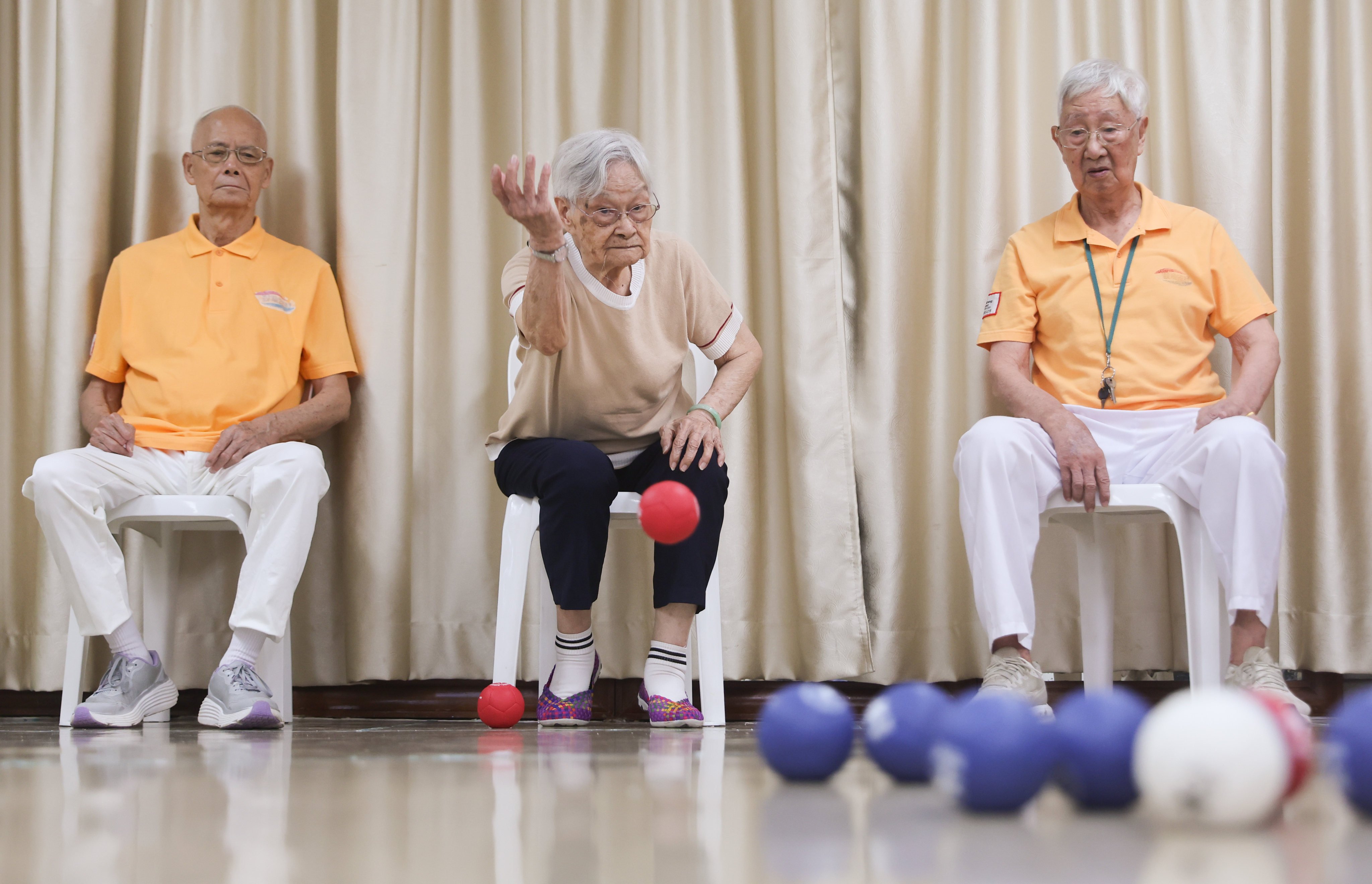 Chow Kam-shim (centre) and her husband Lau Moon-wing (right) play boccia at their elderly residential home. Photo: Edmond So