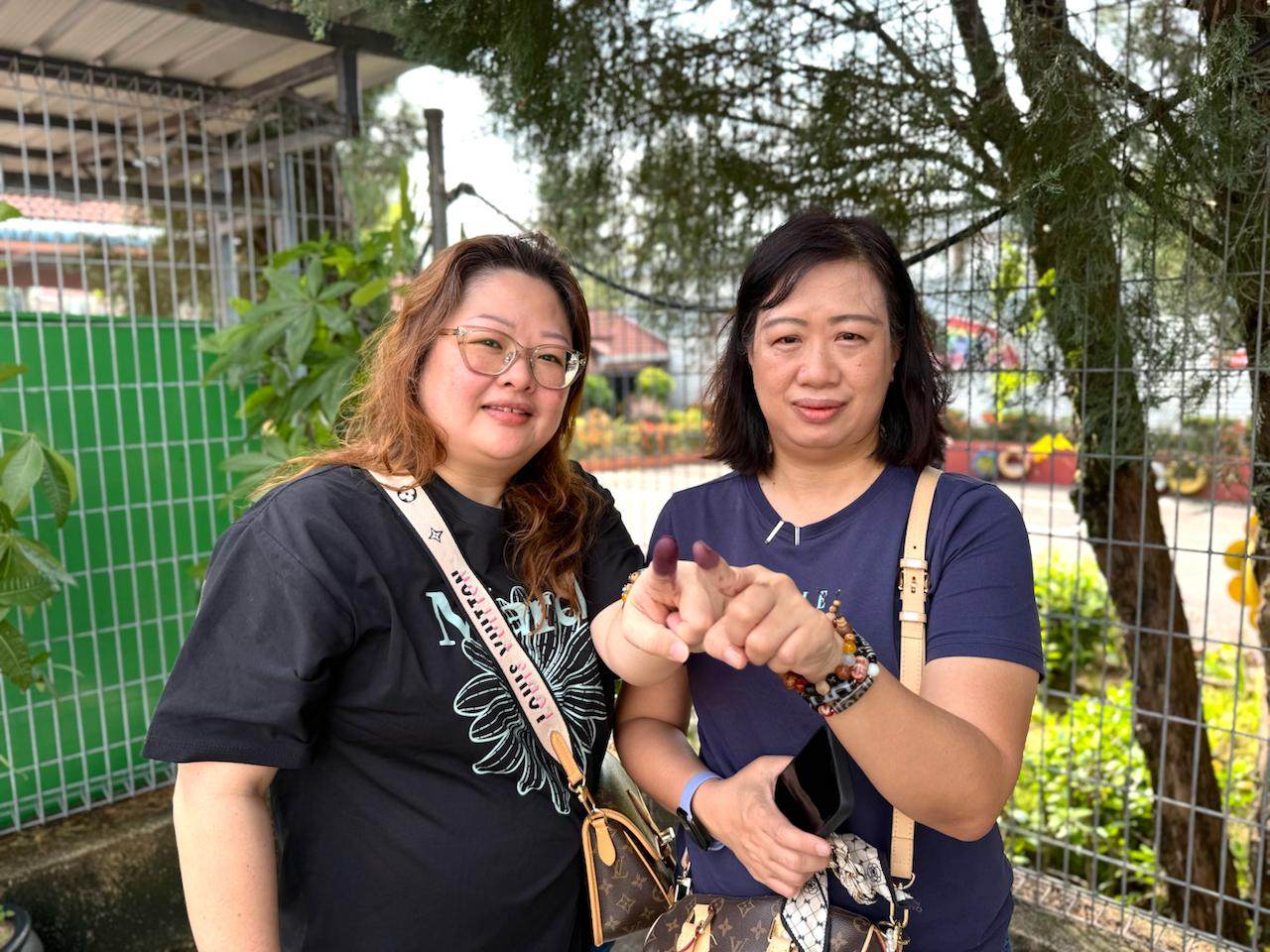 Melanie (right) and her sister show their inked fingers after voting in Johor’s state election on Saturday. Photo: Iman Muttaqin Yusof