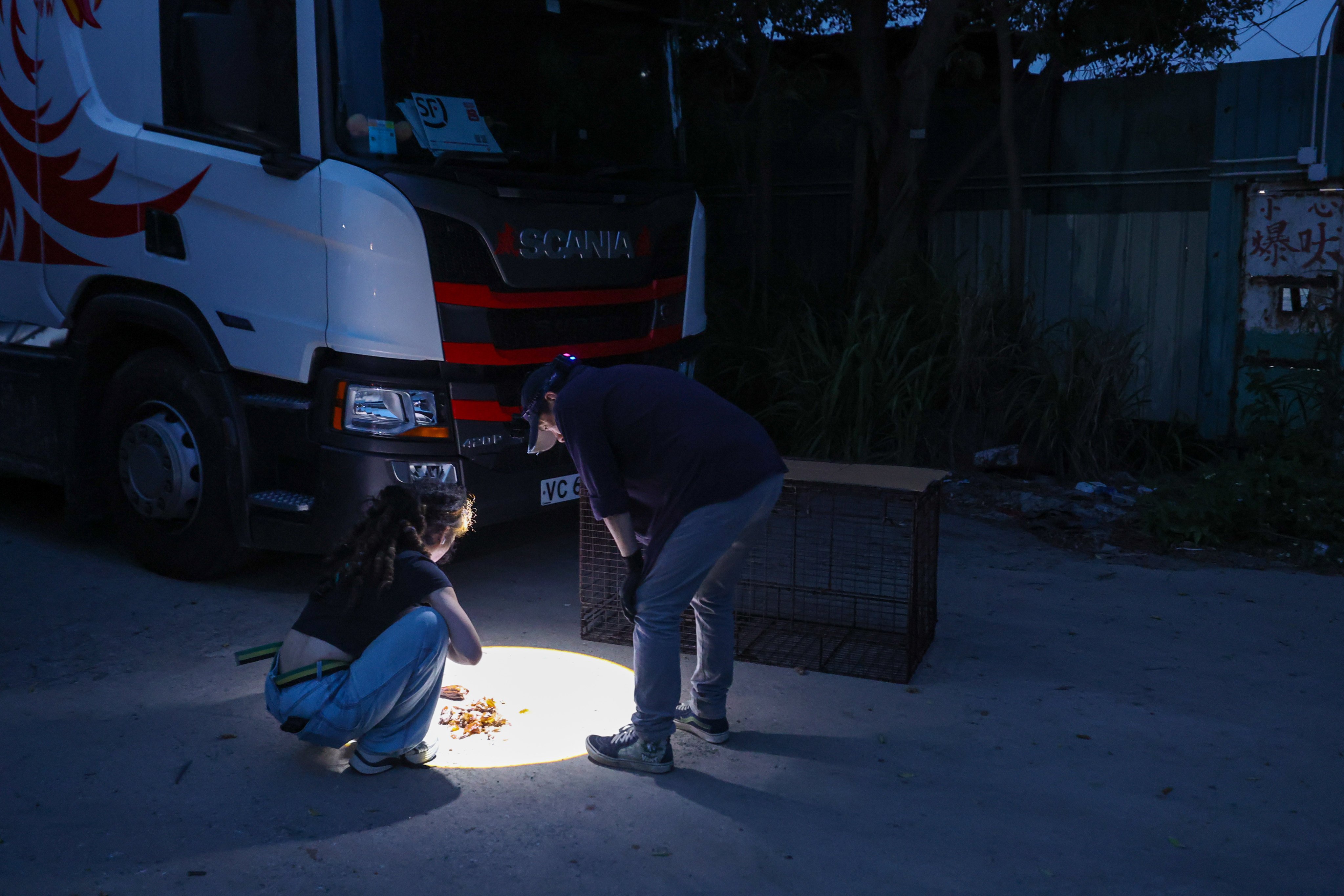 Kent Luk, founder and volunteer of Paws Guardian Rescue Shelter, and volunteer Janette, preparing a trap for stray dogs near Ha Tsuen in the Northern Metropolis. Photo: Edmond So
