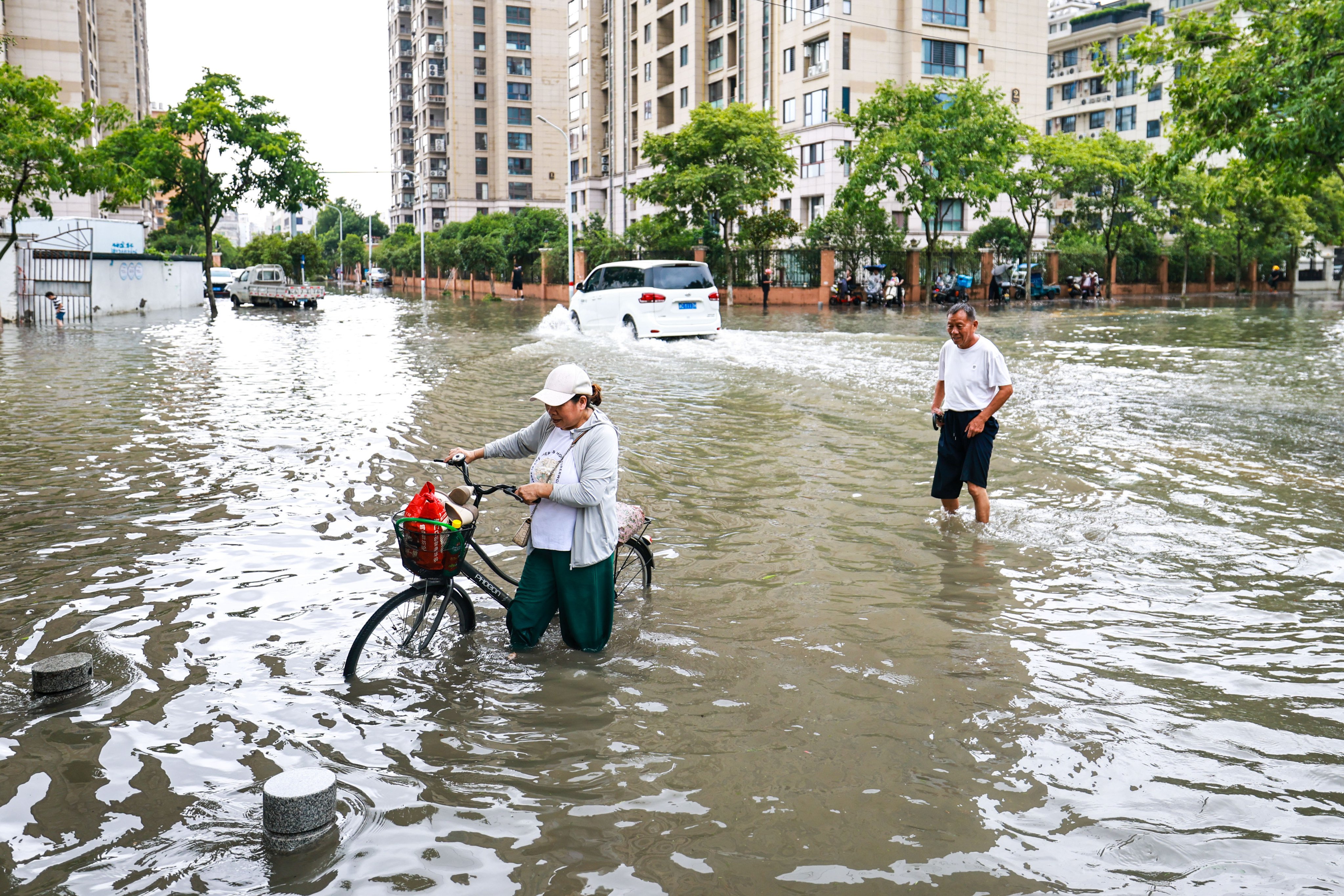 Residents of Yueqing in Wenzhou walk through flooded streets in the aftermath of the storm. Photo: Xinhua