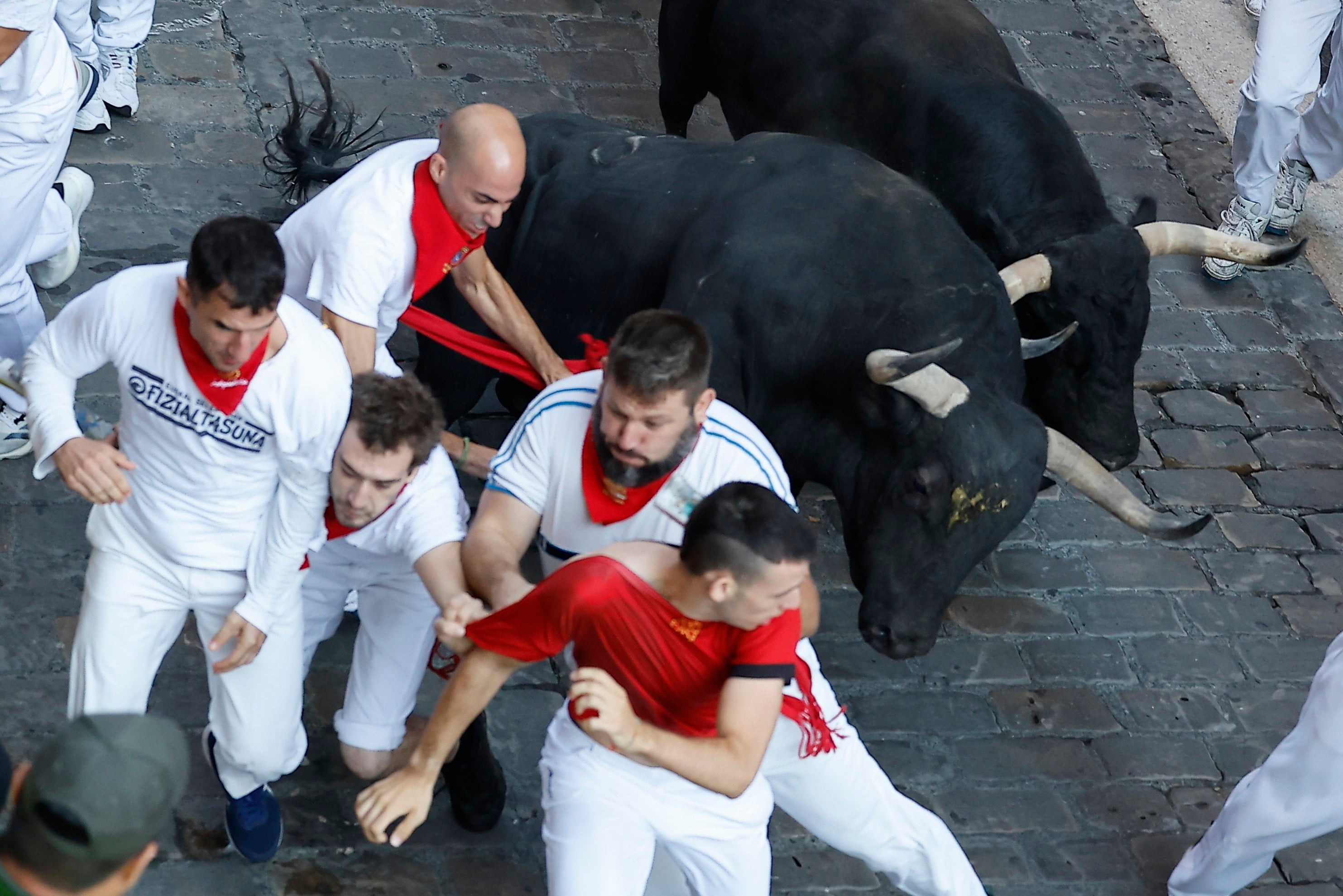 Runners are chased by bulls from the Jandilla ranch during the final run of the San Fermin festival in Pamplona on Tuesday. Photo:   EPA