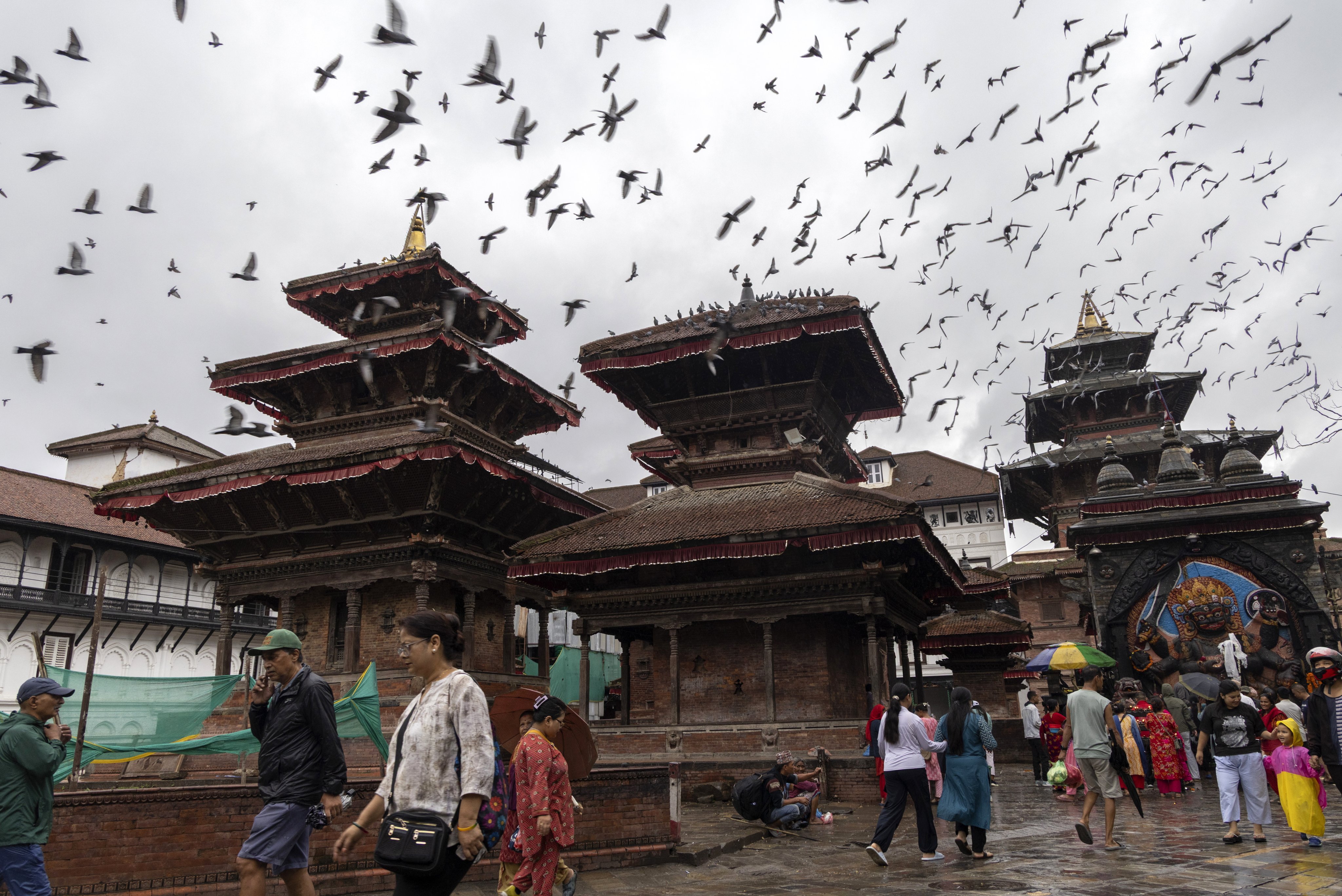 People walk as pigeons fly over Kathmandu Durbar Square in Kathmandu, Nepal, on Monday. Photo: EPA