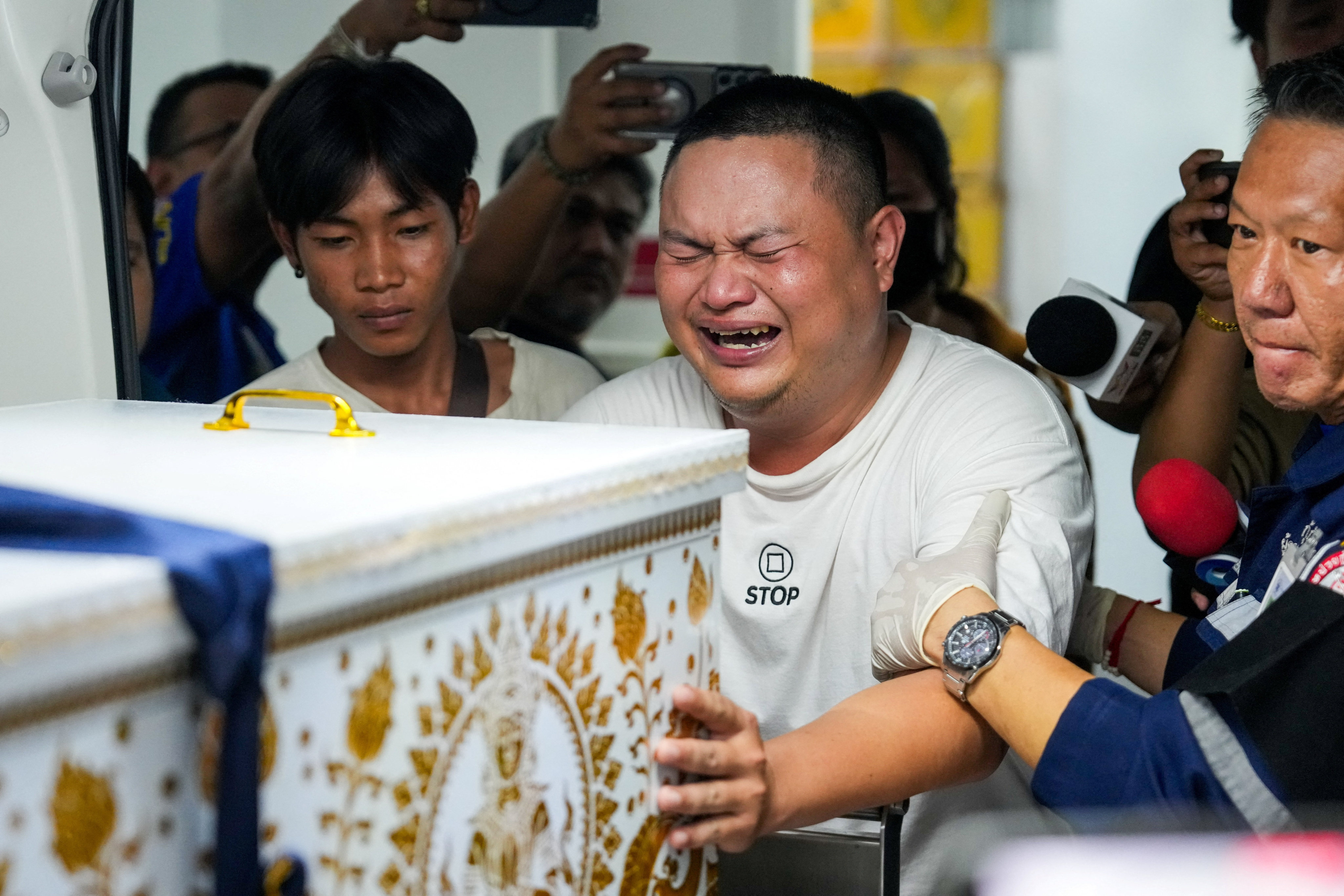 A family member reacts as he receives the body of a victim at the Police Hospital morgue, following a deadly fire at a pub in Bangkok, Thailand, July 13, 2026. REUTERS/Arnun Chonmahatrakool     TPX IMAGES OF THE DAY