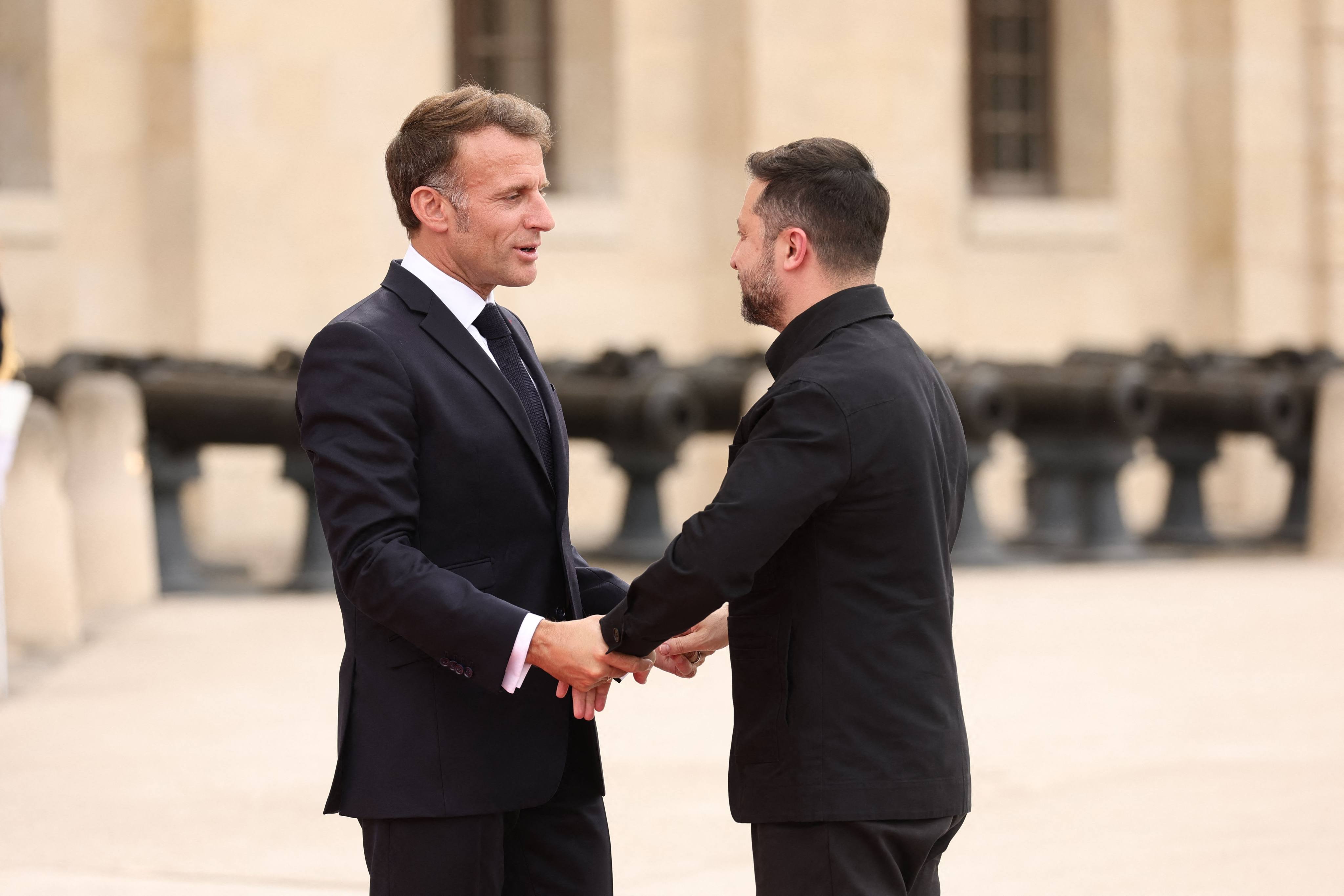 French President Emmanuel Macron, left, greets Ukrainian President Volodymyr Zelensky upon arrival for a summit of the Coalition of the Willing at the Hotel des Invalides in Paris on Monday. Photo: AFP