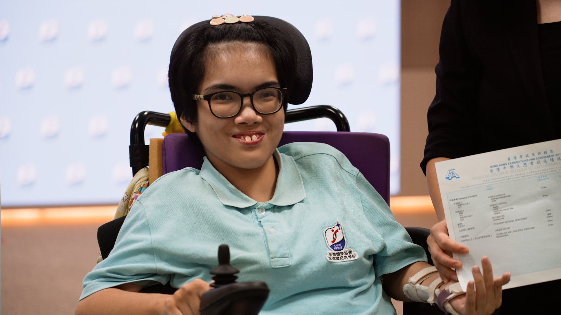 Nineteen-year-old Chang Hoi-ku has achieved a score on Hong Kong’s university entrance exam that is high enough to apply for admission to an Associate’s Degree programme. She achieved the scores on the Diploma of Secondary Education (DSE) despite living with cerebral palsy, hypertonia and paraplegia.