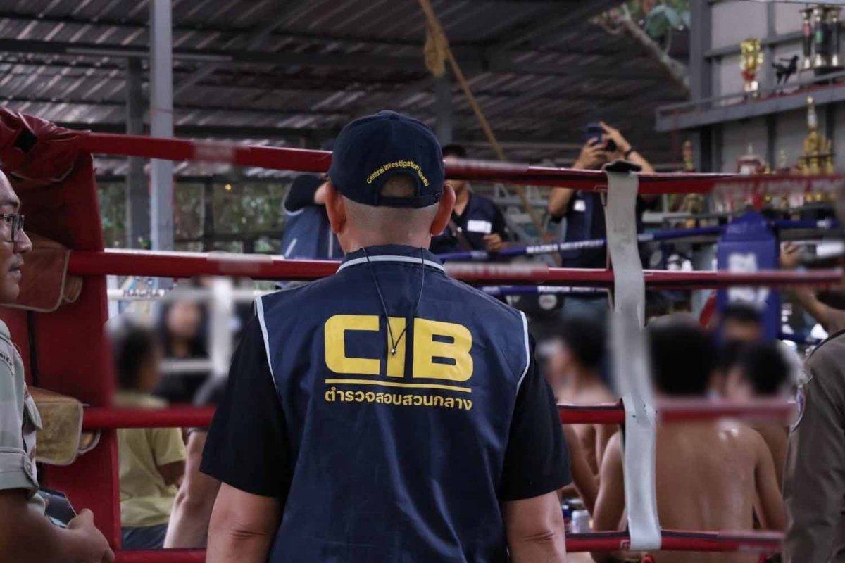 An officer guards the victims after police raid a boxing camp in Rayong province on Tuesday. Photo: Royal Thai Police