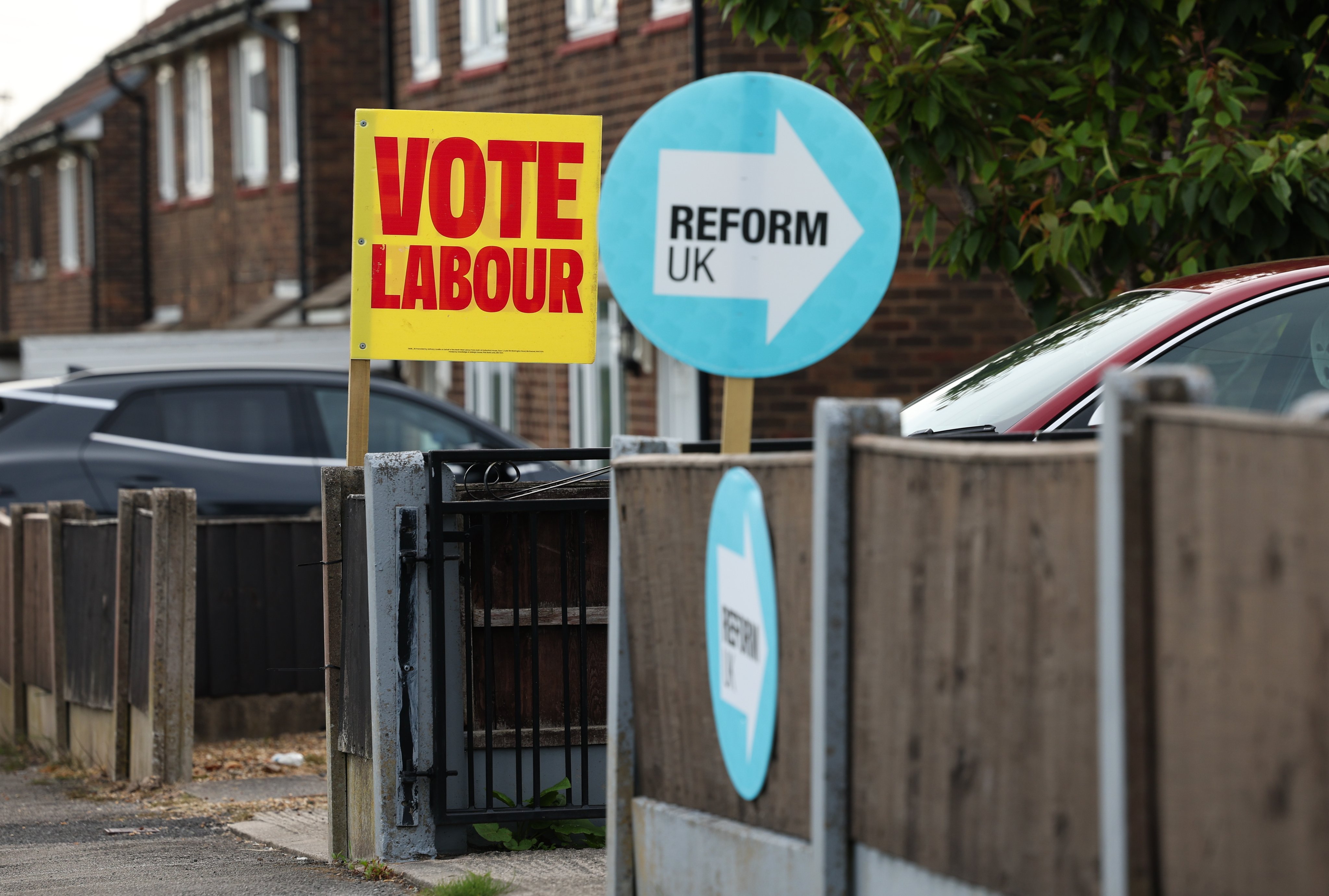 Placards for the Labour party and Reform UK on display outside houses in Wigan, Britain, on June 15. Photo: EPA