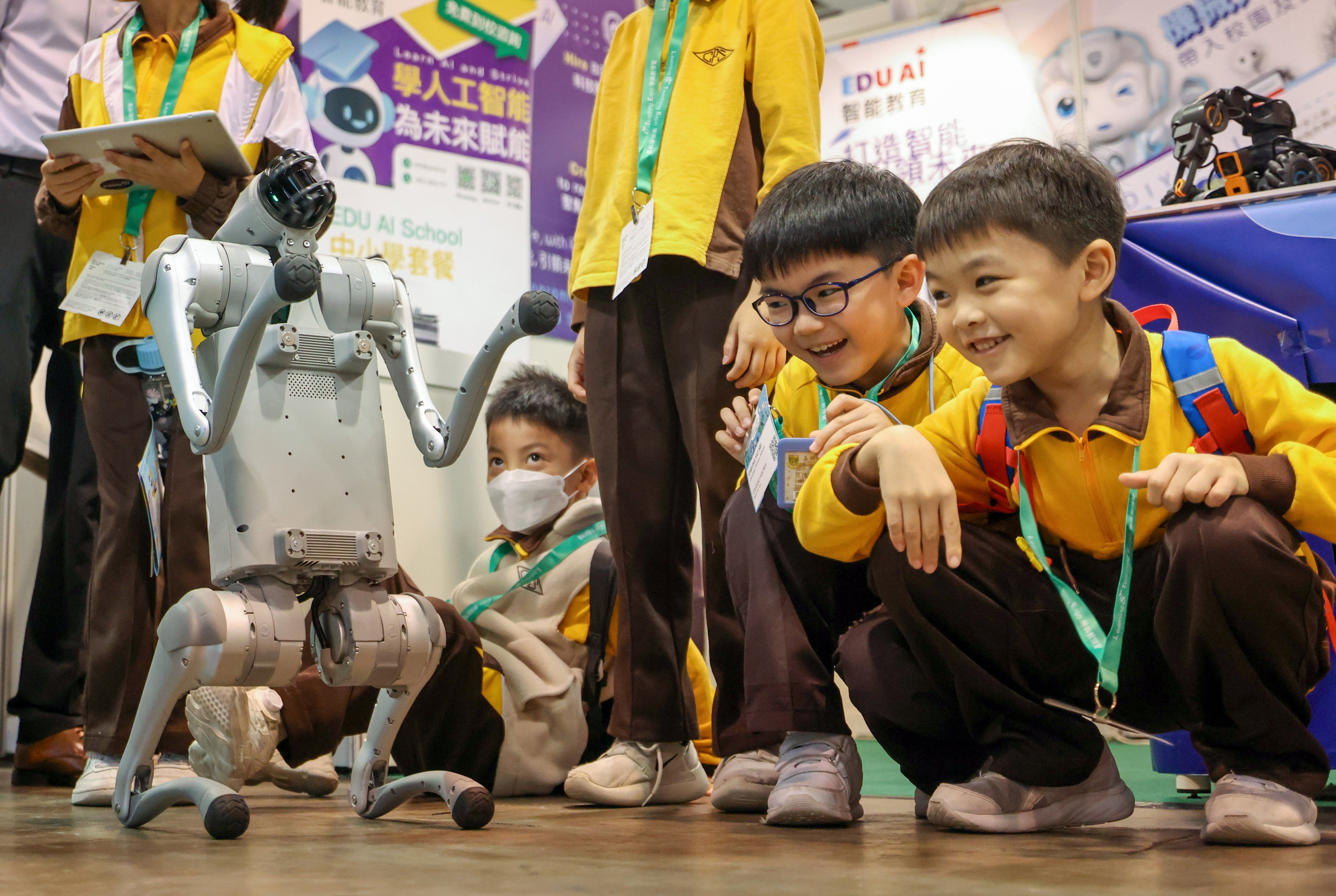 Primary schoolchildren interact with an AI robotic dog during an education and learning expo on December 11, 2024. Photo: Nora Tam