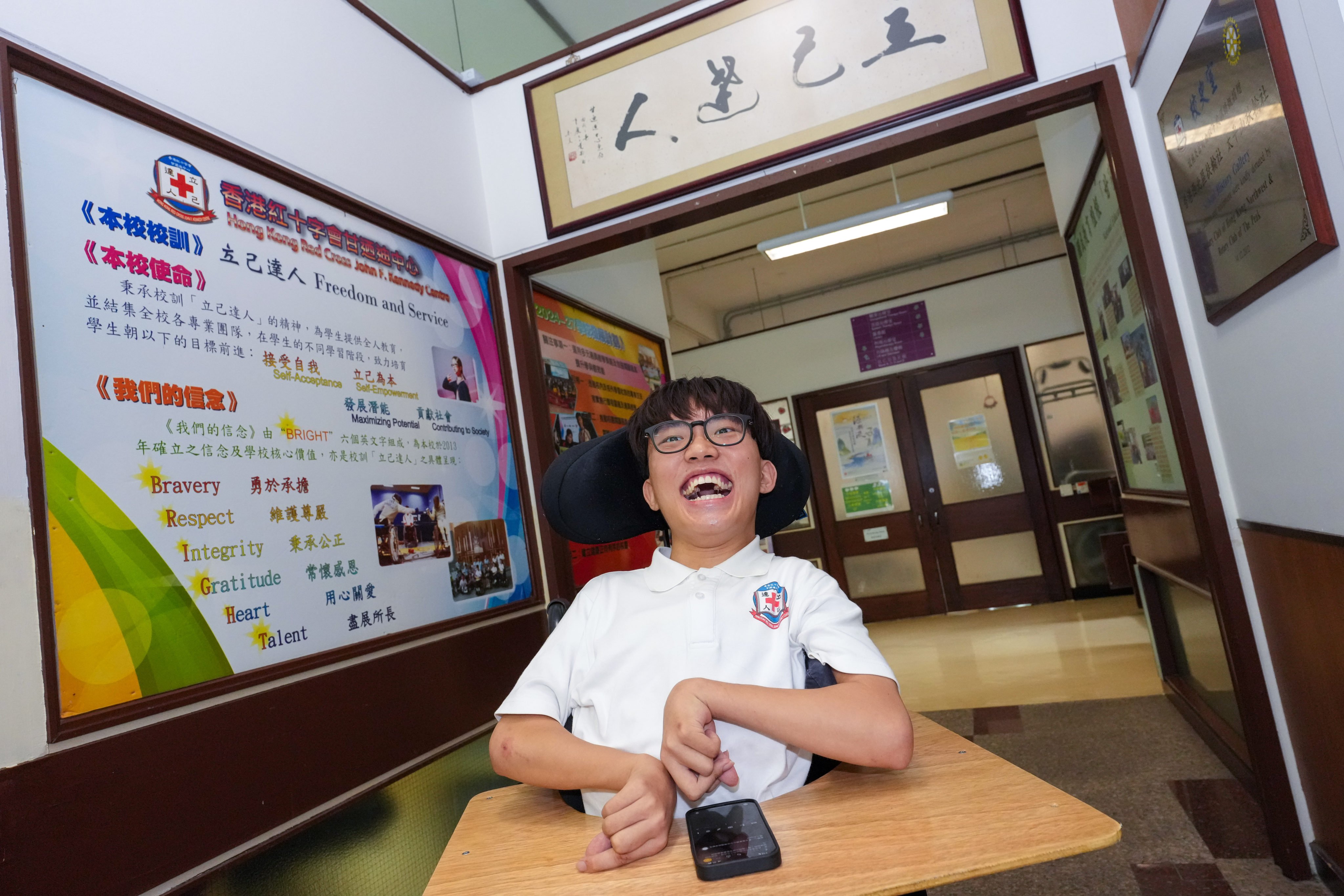 Tam Chun-yu, a student at Hong Kong Red Cross John F Kennedy Centre with severe cerebral palsy and spastic diplegia, used a mobile phone to complete the DSE exams. 
Photo: Jelly Tse