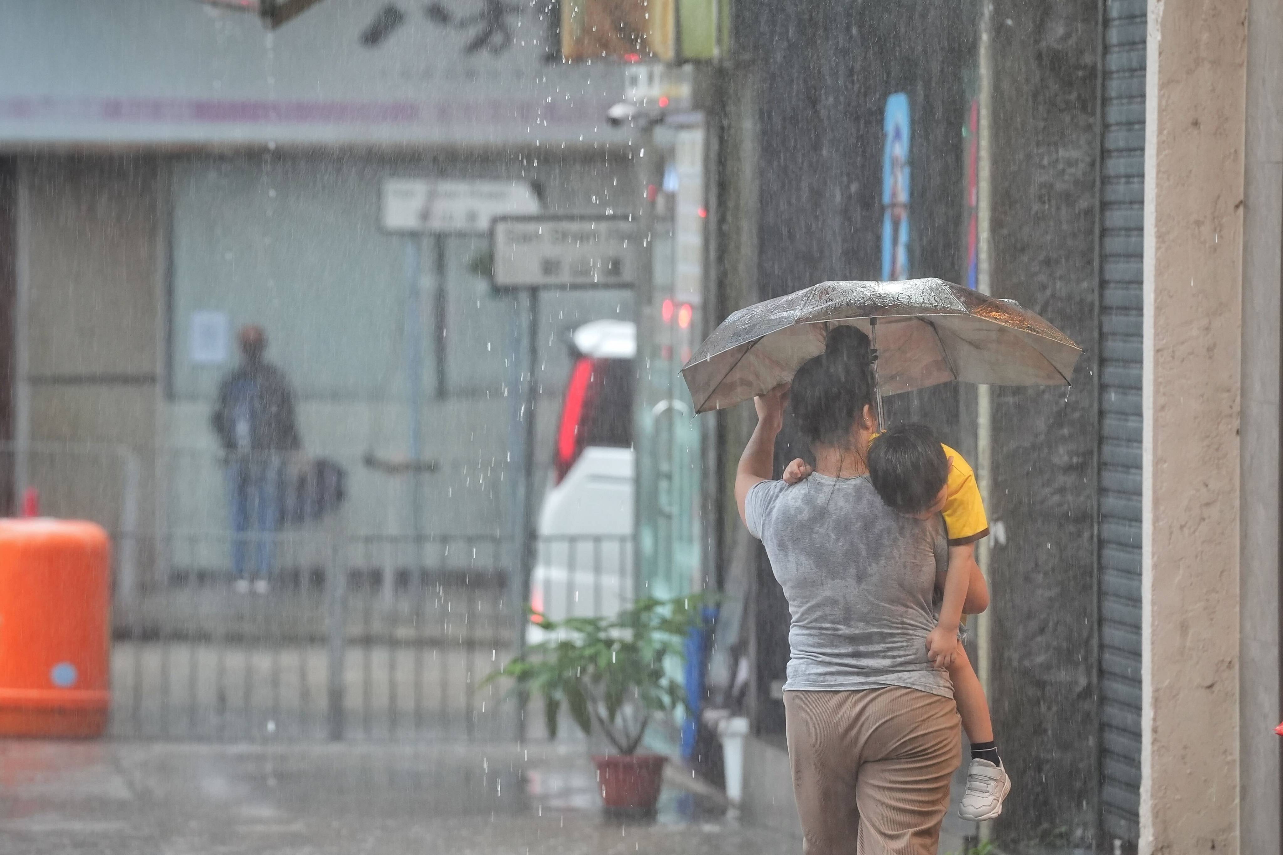 Residents brave the rain in To Kwa Wan. Photo: Elson Li