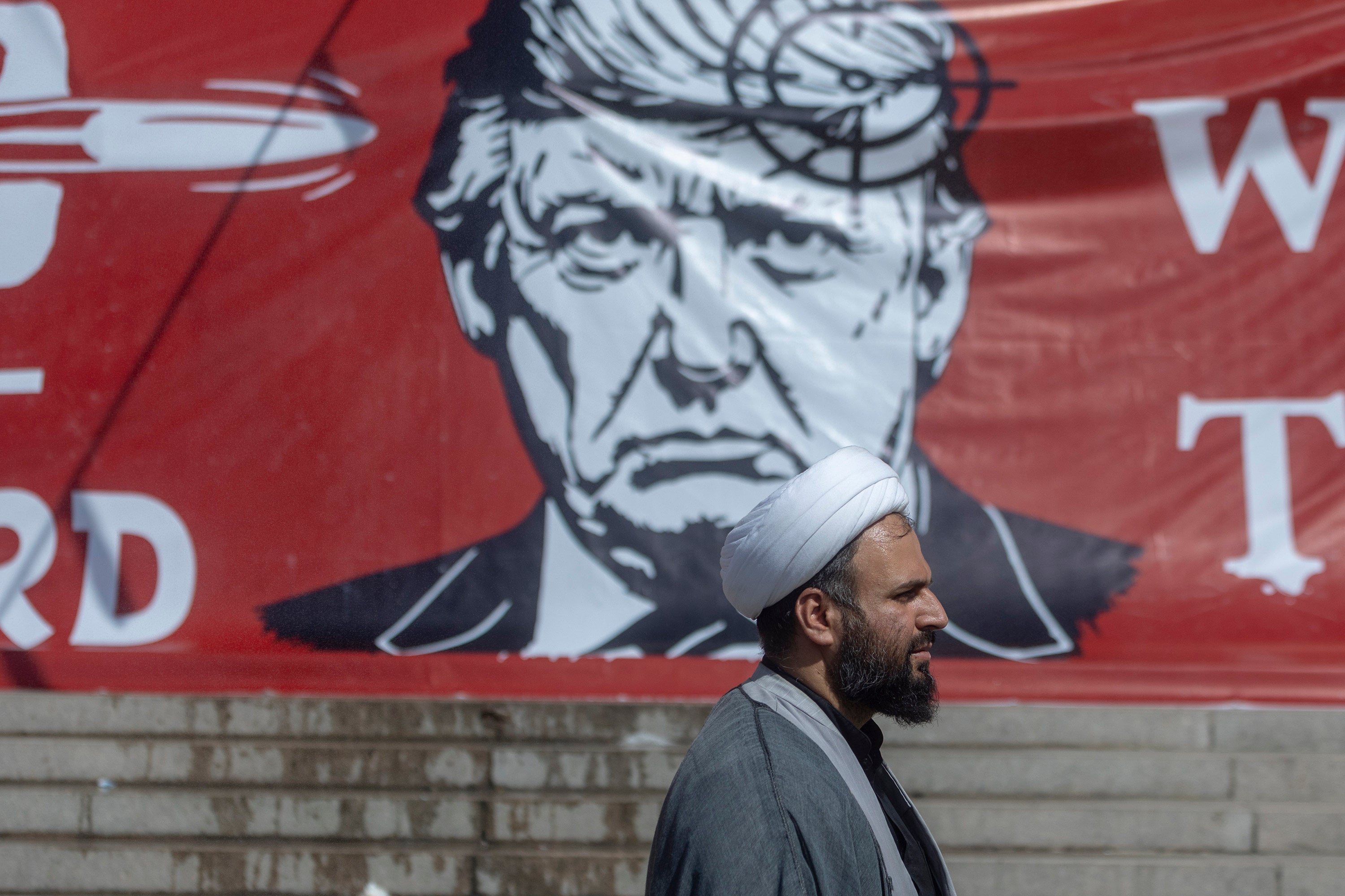 A man walks past a large banner depicting US President Donald Trump with a target on his head, during funeral ceremonies for Iran’s slain leader Ayatollah Ali Khamenei at the Grand Mosalla on July 5. Photo: TNS