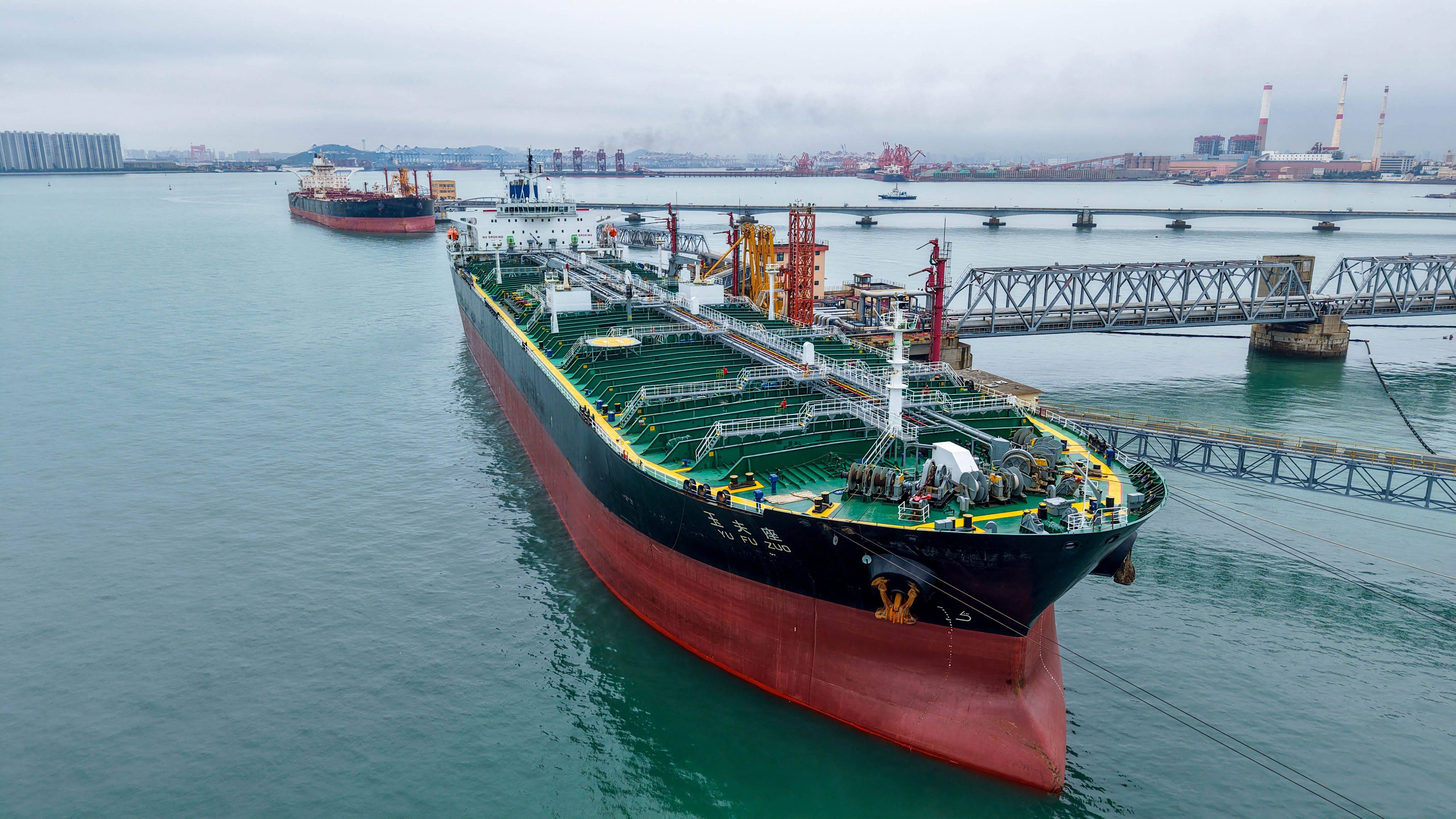 An oil tanker unloads imported crude at Qingdao port, in Chinas eastern Shandong province, on July 16. Photo CN-STR / AFP